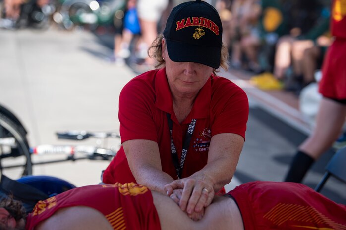 A team Marine Corps  medical staff member provides therapy to an athlete during the 2019 DoD Warrior Games. The Warrior Games showcase the resilient spirit of today’s wounded, ill or injured service members from all branches of the military and provide a venue for recovering service members and veterans to demonstrate triumph over significant physical or invisible wounds and injuries.