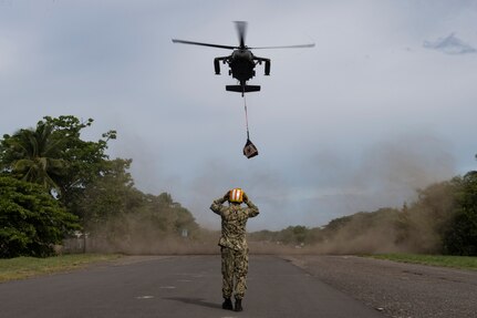 A U.S. Navy sailor deployed to the U.S.N.S. Comfort guides in a UH-60 Blackhawk carrying medical equipment and supplies July 21, 2019, Punta Arenas, Costa Rica. Pilots and aircrew assigned to the 1st Battalion, 228th Aviation transported personnel and equipment to allow the U.S. Naval Ship Comfort to provide medical care to Costa Rican citizens and Venezuelan migrants as part of the United States enduring promise of helping its southern neighbors. The Winged Warriors transported more than 470 people and 20 tons of cargo from July 21 - 30. (U.S. Air Force photo by Staff Sgt. Eric Summers Jr.)