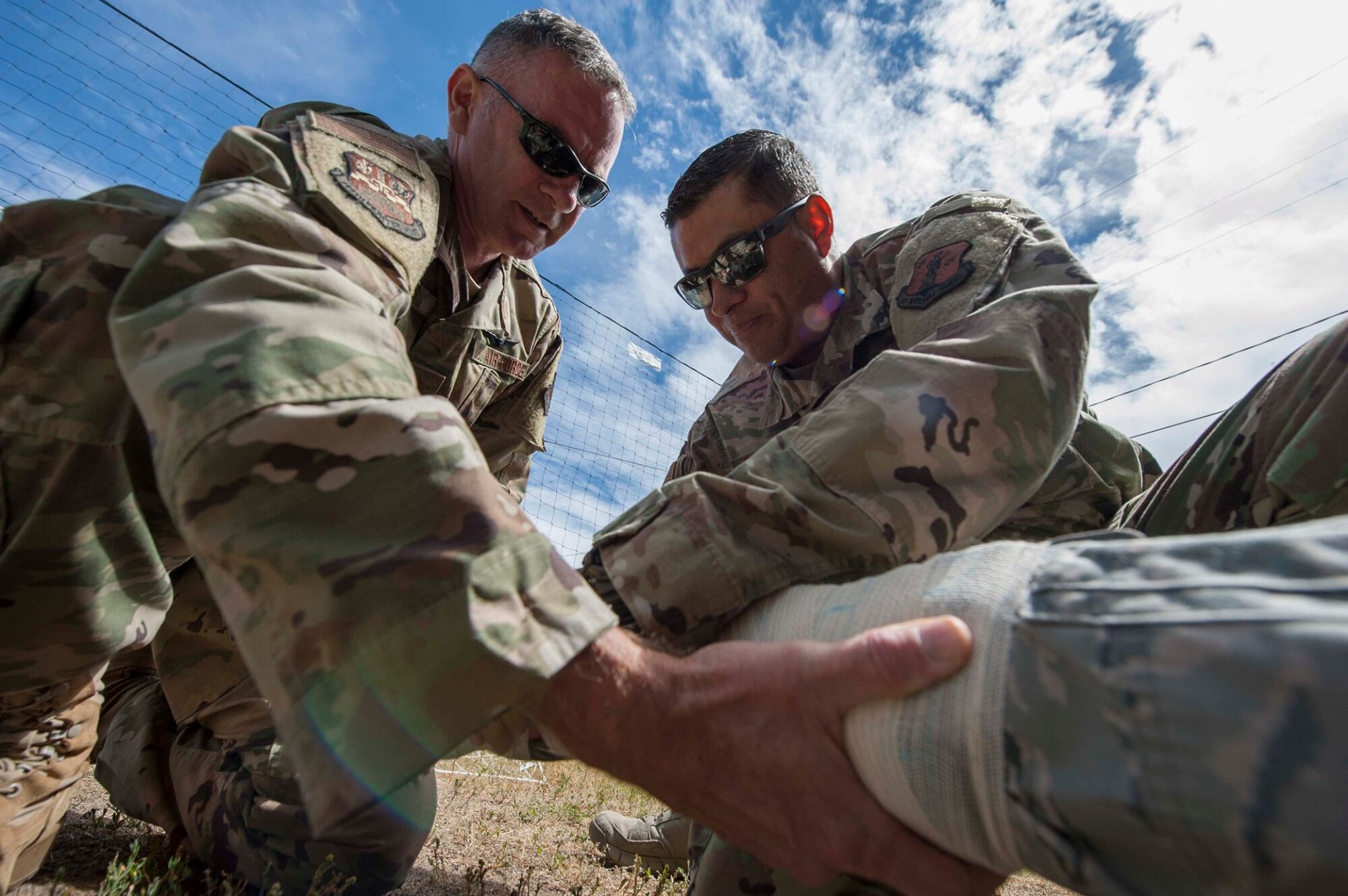 Maj. Christopher Lopes and Tech. Sgt. John Castillo, both members, assigned to the 149th Medical Group, apply a splint to an actor during Tactical Combat Casualty Care training at Coast Guard Station Lake Tahoe, Nevada June 16.