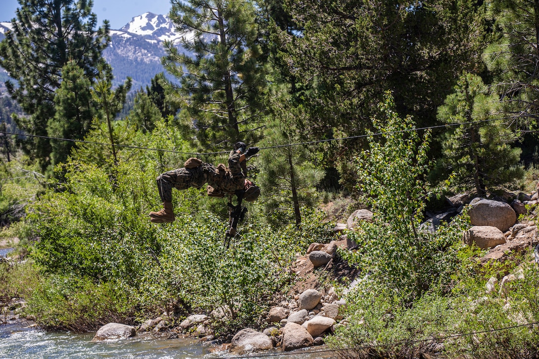 A U.S. Marine with Golf Company, 2nd Battalion, 3rd Marine Regiment, crosses a one-rope bridge during Mountain Exercise (MTX) 4-19 at the Mountain Warfare Training Center, Bridgeport, CA, July 19, 2019. The purpose of the MTX is to provide a training and assessment that challenges units to plan and perform operational tasks across the warfighting functions in mountainous environment. (U.S. Marine Corps photo by Lance Cpl. Jacob Wilson)