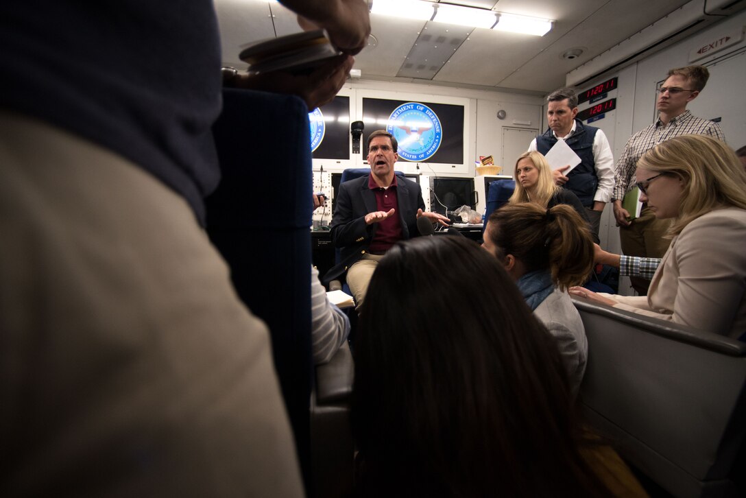 Man surrounded by reporters.