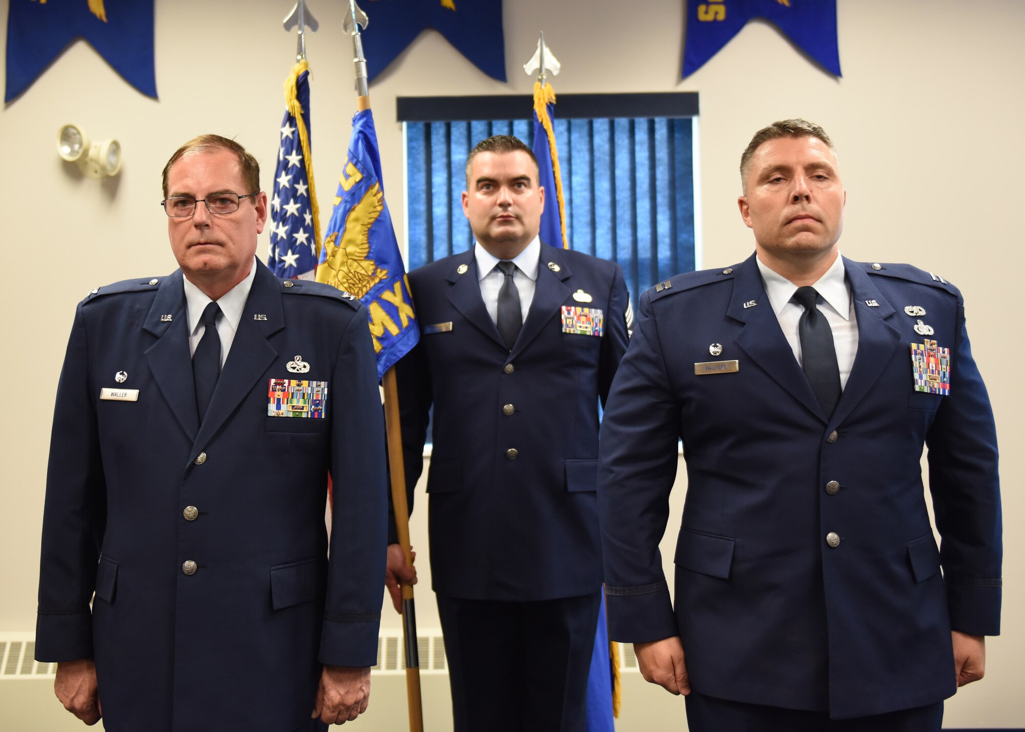 Capt. Joseph E. Walters, commander of the 911th Aircraft Maintenance Squadron, Col. Clifford Waller, commander of the 911th Maintenance Group, and Chief Master Sgt. Benjamin Waxenfelter, production supervisor with the 911th Aircraft Maintenance Squadron, stand at attention during an assumption of command ceremony at the Pittsburgh International Airport Air Reserve Station, Pennsylvania Aug. 3, 2019.