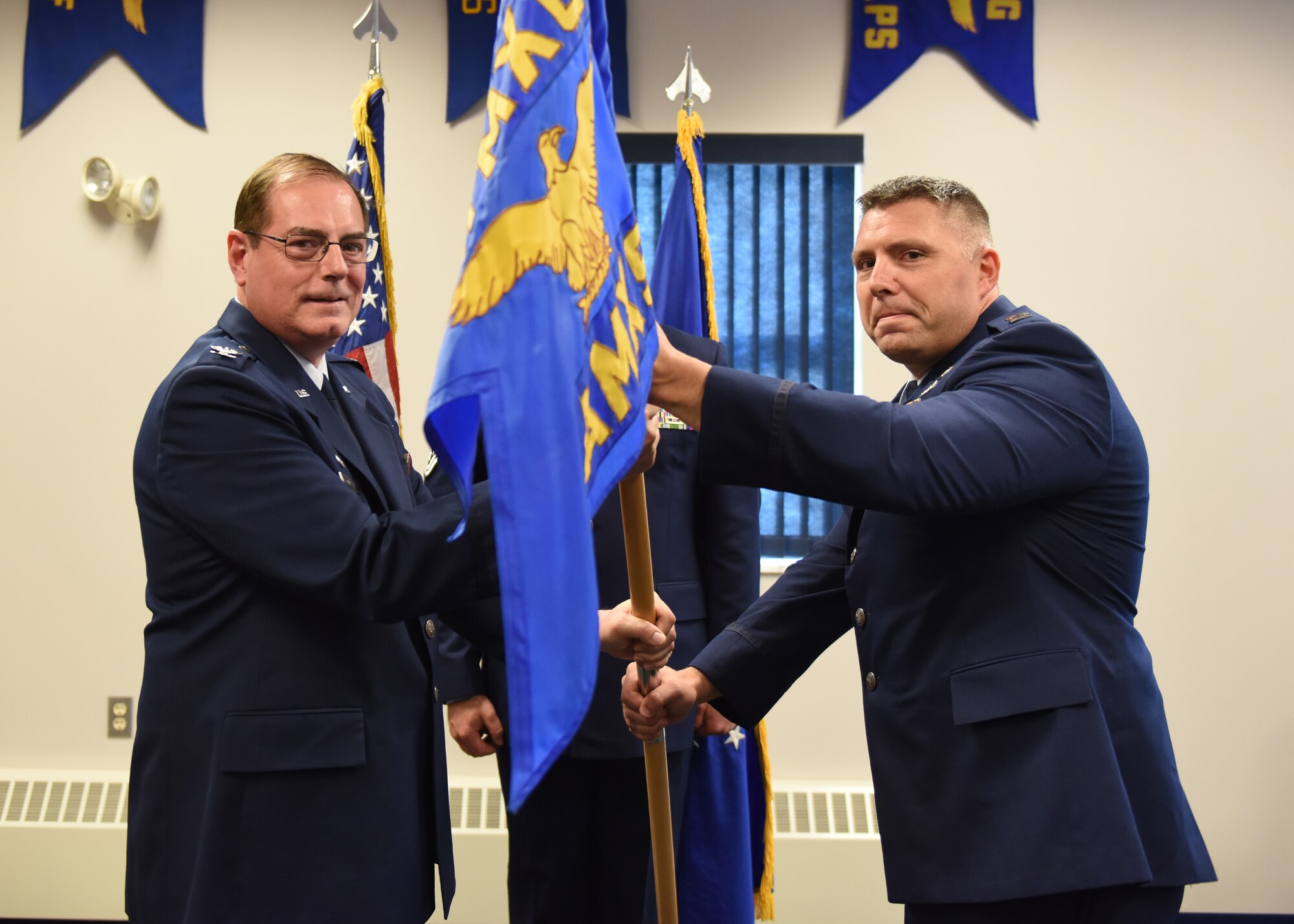 Capt. Joseph E. Walters, commander of the 911th Aircraft Maintenance Squadron, and Col. Clifford Waller, commander of the 911th Maintenance Group, pose for a photo with the squadron flag during an assumption of command ceremony at the Pittsburgh International Airport Air Reserve Station, Pennsylvania Aug. 3, 2019.
