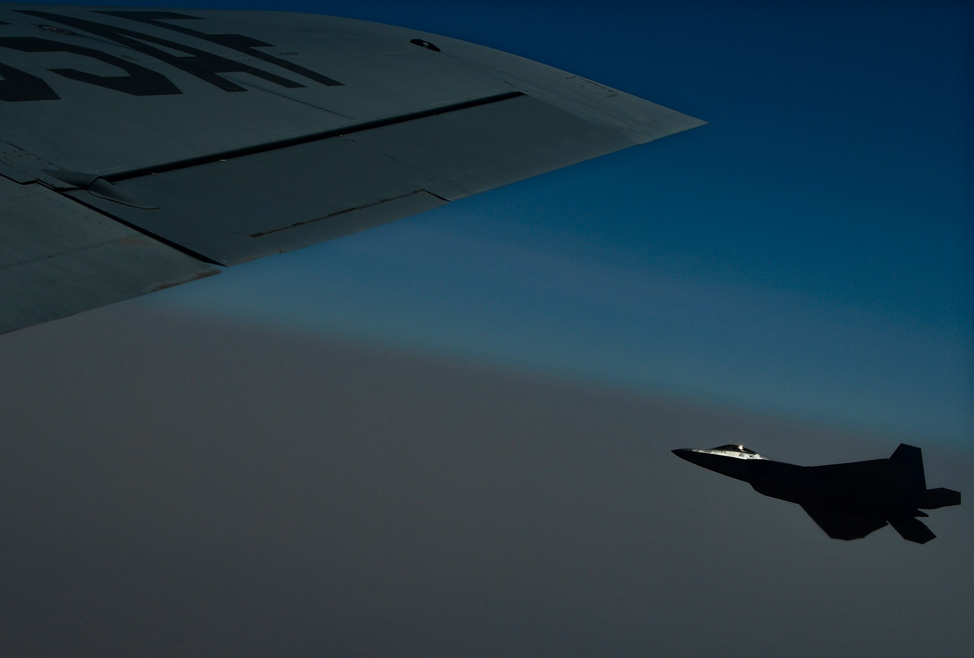 A photo of an F-22 flying alongside a KC-135