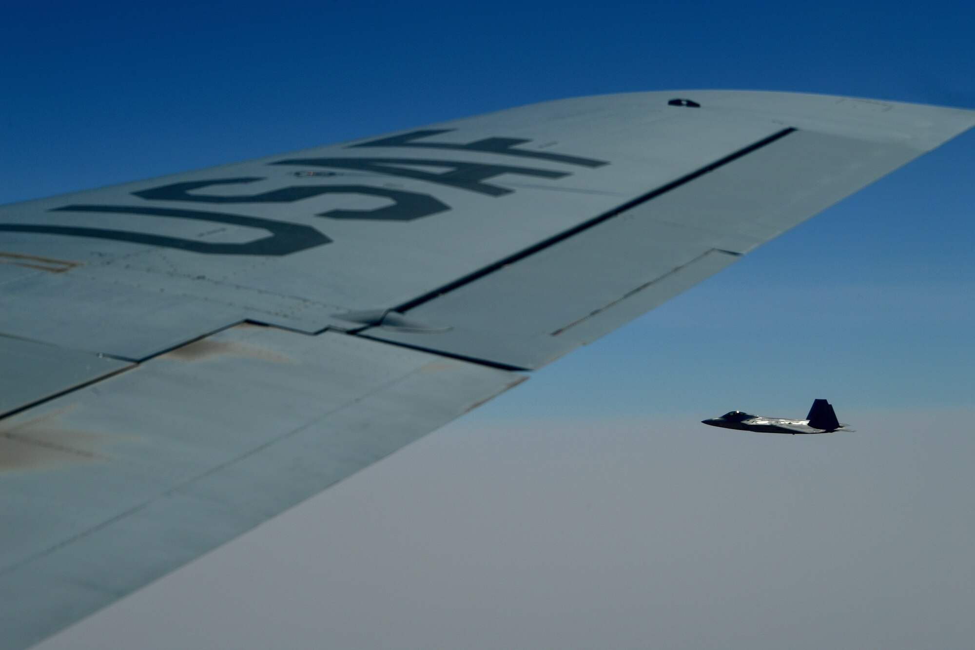 A photo of an F-22 flying alongside a KC-135