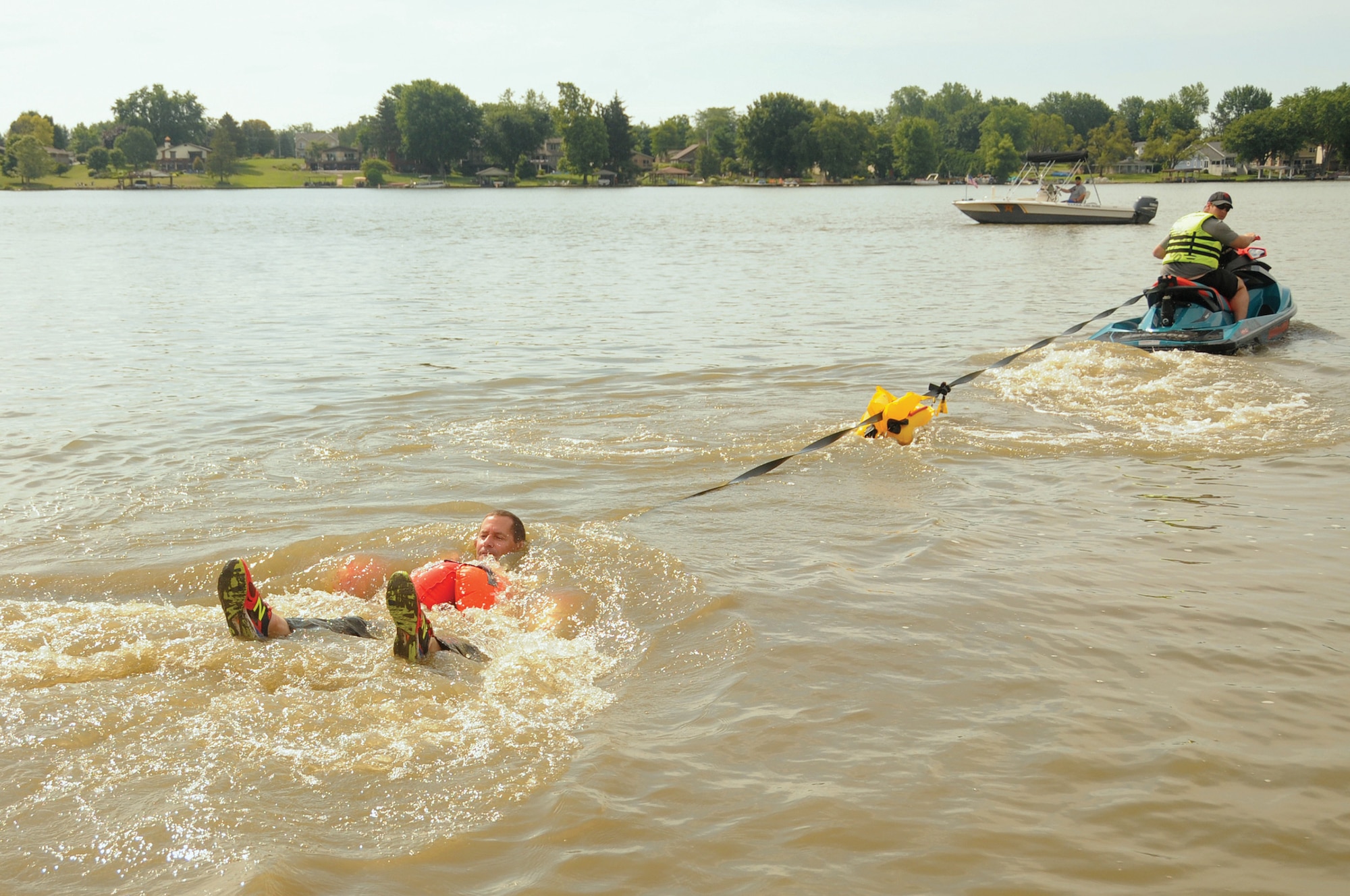Col. John Robinson, 445th Operations Group commander, is dragged through the water by Tech. Sgt. Mackenzie Thompson, 445th Operations Support Squadron aircrew flight equipment technician, at Choctaw Lake July 14, 2019. This training simulates the dragging motion experienced when landing in water with a parachute.