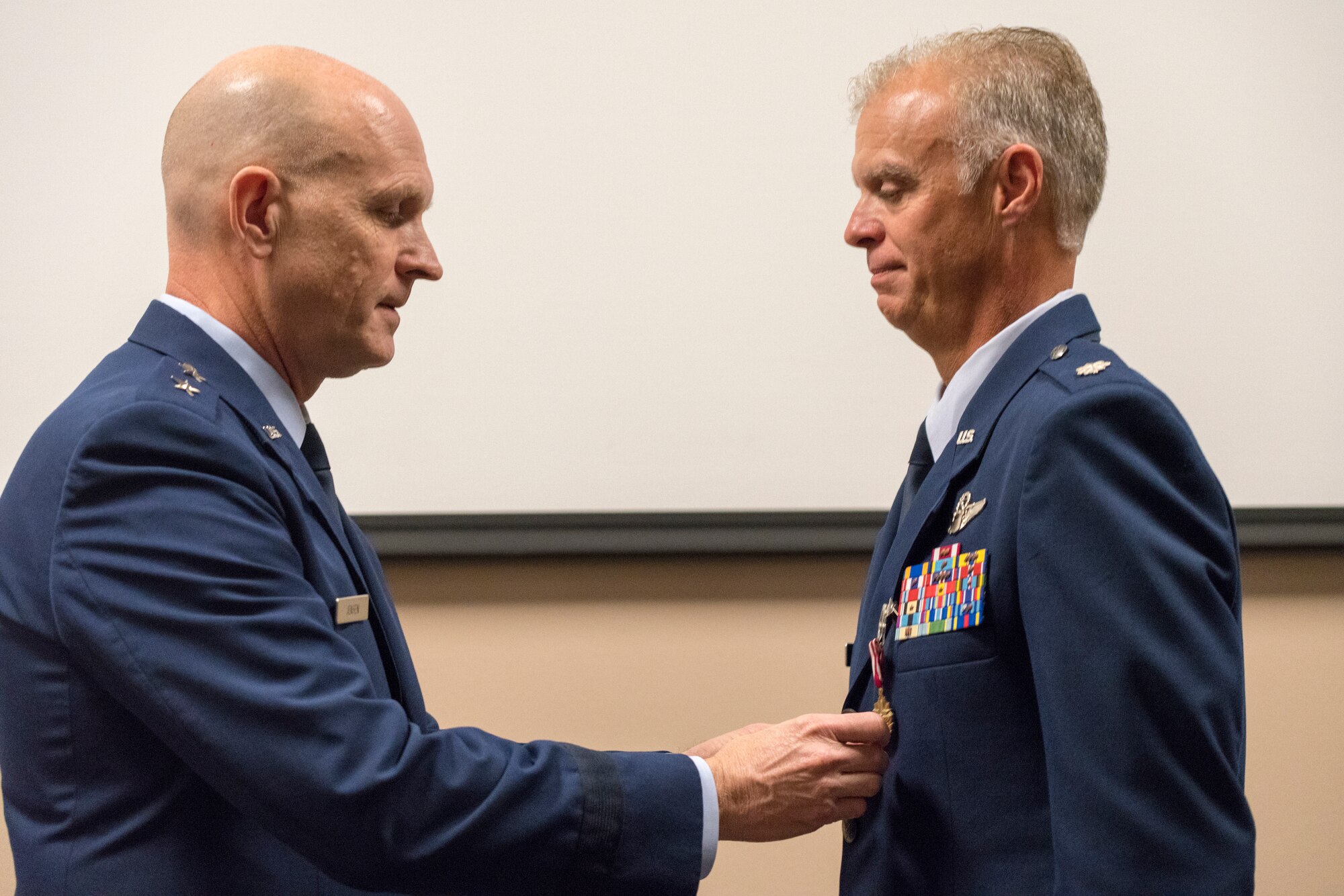 Maj. Gen. Jay Jensen, Director of Plans, Programs and Requirements, Headquarters Air Force Reserve Command, pins the Meritorious Service Medal on Lt. Col. Keith Gibson, 403rd Wing Operation’s Group deputy commander, during Gibson’s retirement ceremony Aug. 3, 2019 at Keesler Air Force Base, Mississippi. Gibson completed his Air Force career with 29 years of service. (U.S. Air Force photo by Tech. Sgt. Christopher Carranza)