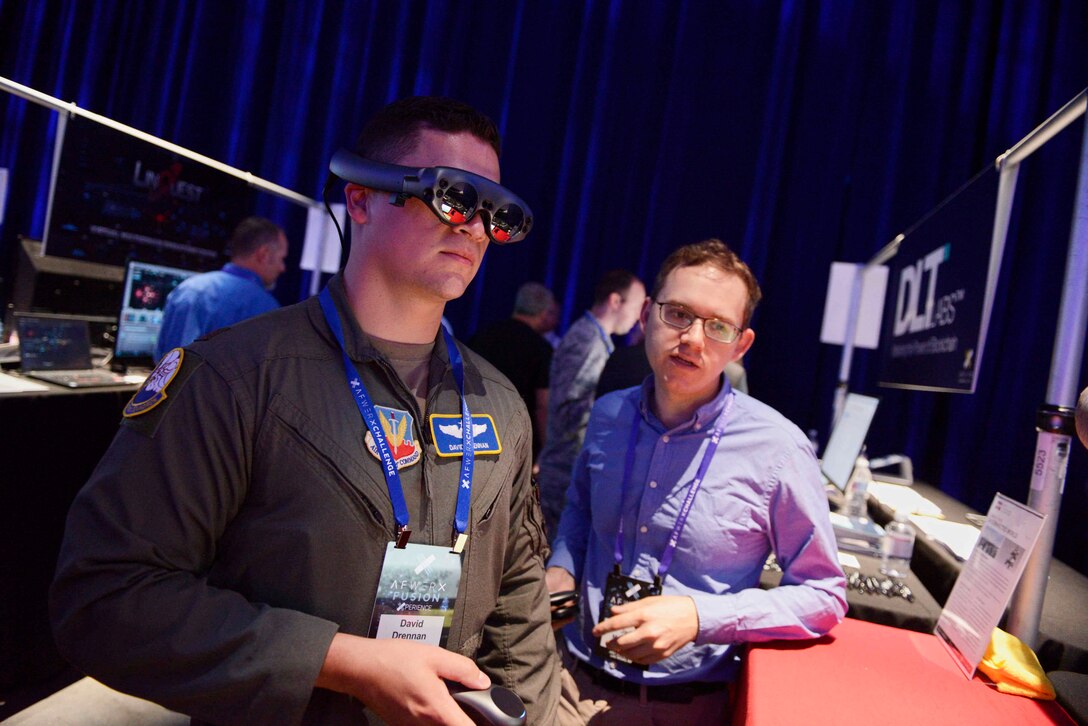 An AFWERX Fusion exhibitor demonstrates his Multi-Domain Operations-related product for an attendee during the event on July 23 in Las Vegas. The annual event featured speakers, panels and product showcases focused on solving U.S. Air Force challenges with existing commercial products and concepts. (U.S. Air Force photo by Bridget Bennett)