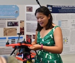 IMAGE: DAHLGREN, Va. (July 25, 2019) — University of Virginia junior Kimberly Louie explains how the deck-gun she helped create and attach to a drone operates while briefing to military and government personnel during her 2019 summer internship. Louie was among 20 students who completed their internships at Naval Surface Warfare Center Dahlgren Division (NSWCDD). The Naval Research Enterprise Internship  Program (NREIP) encourages students to pursue science and engineering careers, furthers education via mentoring and their participation in research, and makes them aware of Navy research and technology efforts, which can lead to civilian employment within the Navy.