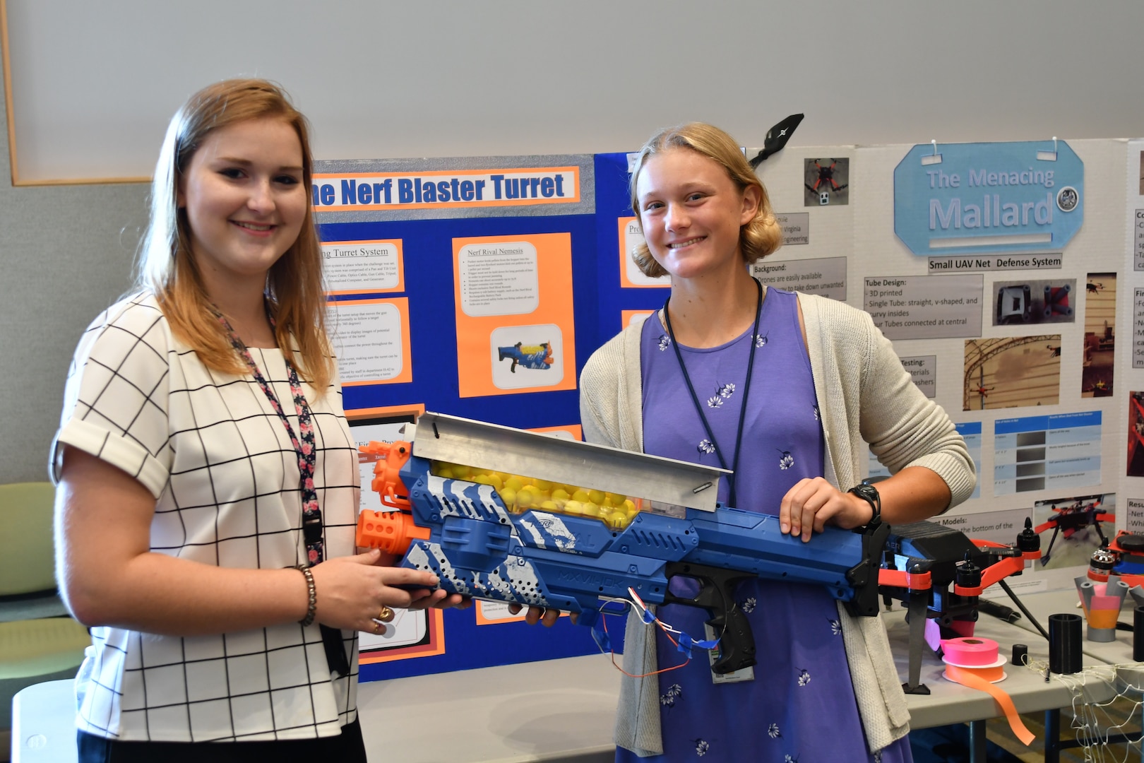 IMAGE: DAHLGREN, Va. (July 25, 2019) — Margot Adams (left) and Chaney Ganninger brief attendees on their integration of a Nerf gun into an autonomous turret gun system. They were among students who completed their summer internships at Naval Surface Warfare Center Dahlgren Division. The Science and Engineering Apprenticeship Program (SEAP) encourages participating high school students to pursue science and engineering careers, to further their education via mentoring by laboratory personnel and their participation in research, and to make them aware of DoN research and technology efforts, which can lead to employment within the DoN.