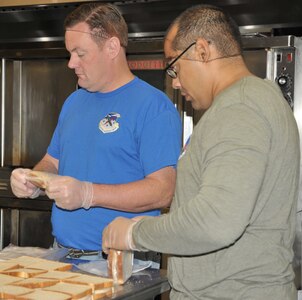 Lt. Col. Samuel Moore (blue shirt) and Tech. Sgt. Christian Delgado, from the 340th Flying Training Group headquarters, help prepare sandwiches for nearly 1,000 lunches that will be provided to food insecure children in the San Antonio multi-county region. Group members volunteered July 12 to support the San Antonio Food Bank’s Million Summer Meals for Kids campaign focused on bridging the gap during the summer months, when many kids may not have regular access to food.