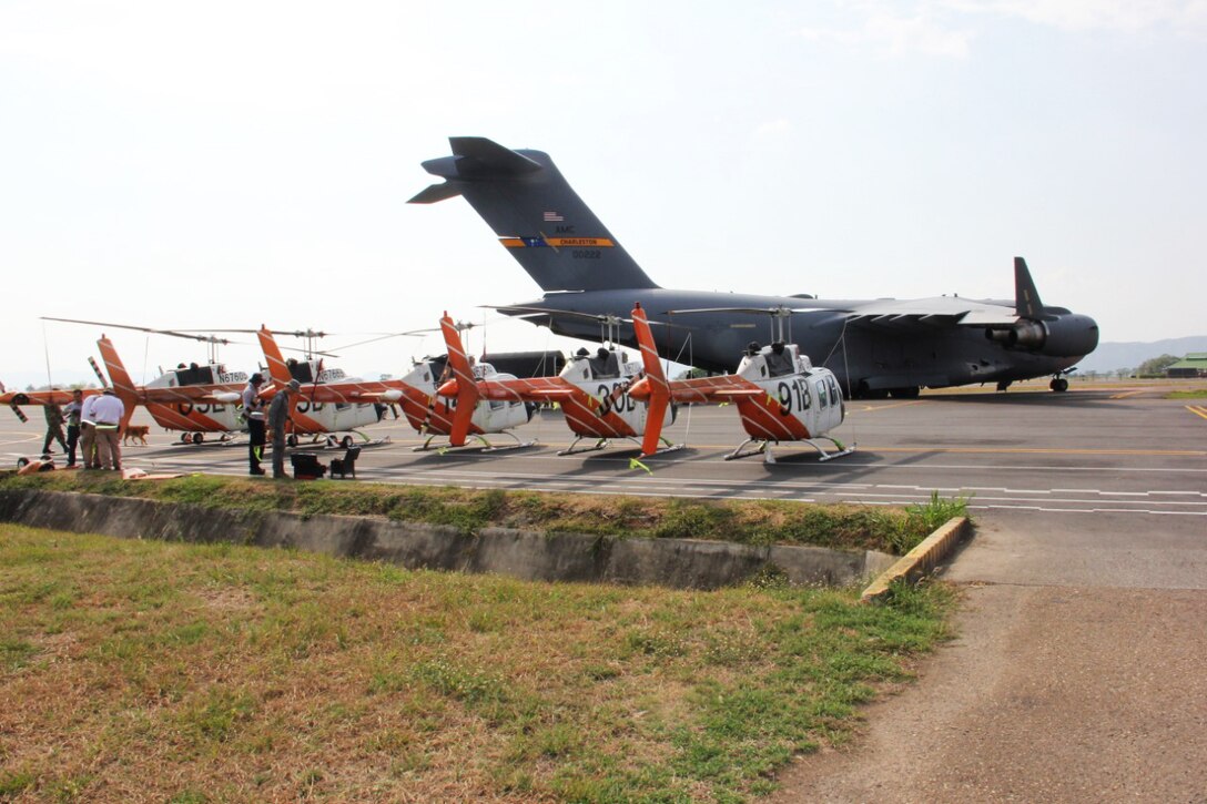 Five helicopters sit on the tarmac at Bogota El Dorado International Airport.