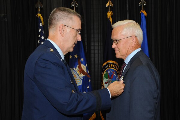 U.S. Air Force Gen. John Hyten, commander of U.S. Strategic Command, presents the Joint Distinguished Civilian Service Award  to Pat McVay, director of joint exercises, training and assessments, and a Senior Executive Service member, during his retirement ceremony in Bellevue, Neb., July 26, 2019.