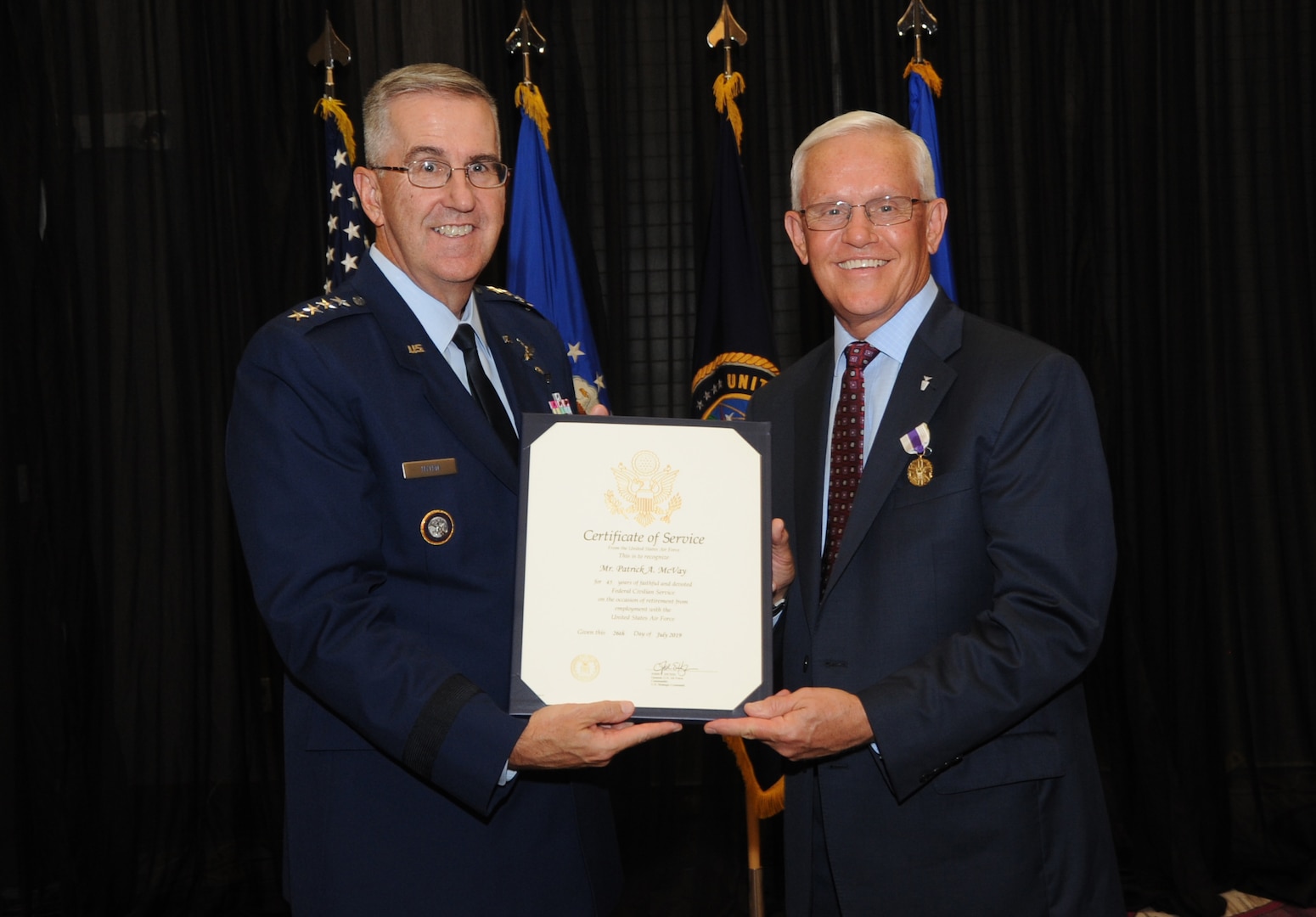 U.S. Air Force Gen. John Hyten, commander of U.S. Strategic Command, presents a certificate of service to Pat McVay, director of joint exercises, training and assessments, and a Senior Executive Service member, during his retirement ceremony in Bellevue, Neb., July 26, 2019.
