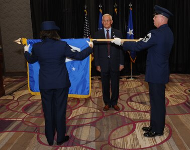U.S. Air Force members Staff Sgt. Grace Gonzalez (left) and Chief Master Sgt. Richard Dawson (right) furl Pat McVay’s (center), director of joint exercises, training and assessments, Senior Executive Service flag during his retirement ceremony in Bellevue, Neb., July 26, 2019.