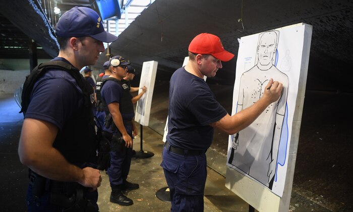 U.S. Coast Guard Petty Officer 1st Class Christopher Thomas, USCG Sector Charleston armory lead petty officer, right, evaluates the performance of Ensign Oliver Kremer, USCG Cutter Hamilton law enforcement officer, left, at Joint Base Charleston, S.C., Aug. 1, 2019. Coast Guard combat arms instructors from USCG Sector Charleston assisted in the evaluation of the guardsmen to ensure they were ready and worldwide qualified for their next mission. Combat Arms Training and Maintenance instructors support the readiness of Joint Base Charleston’s mission partners through training and evaluating service members on proficiently operating and safely handling their weapons. The partnership between Air Force and Coast Guard personnel supports USCG Sector Charleston in their mission of performing maritime safety, security and stewardship in their area of responsibility.