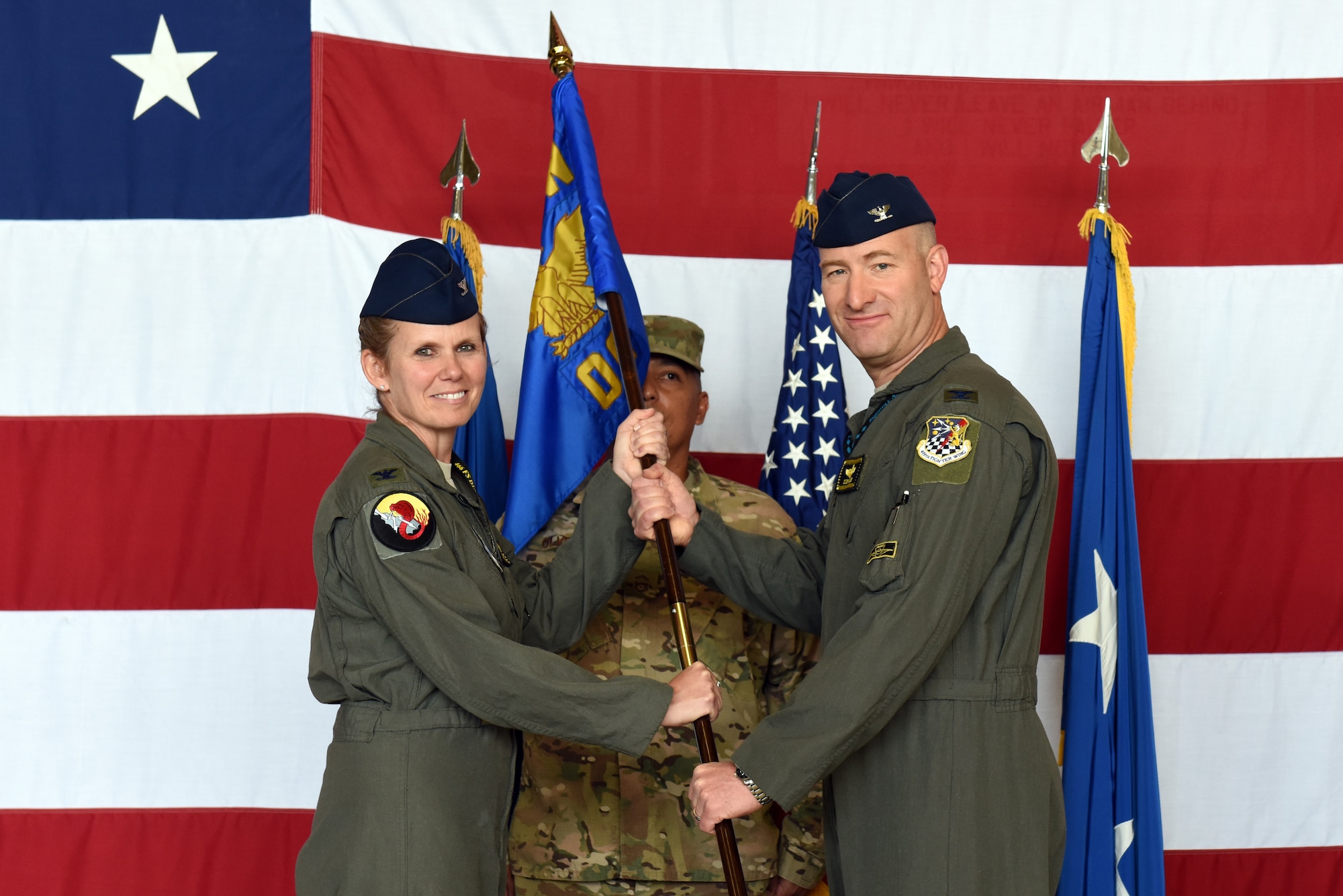 Col. Regina Sabric, 419th Fighter Wing commander, passes the group flag to Col. Mathew Miller, the new commander of the 419th Operations Group, during a change of command ceremony Aug. 3, 2019, at Hill Air Force Base, Utah.