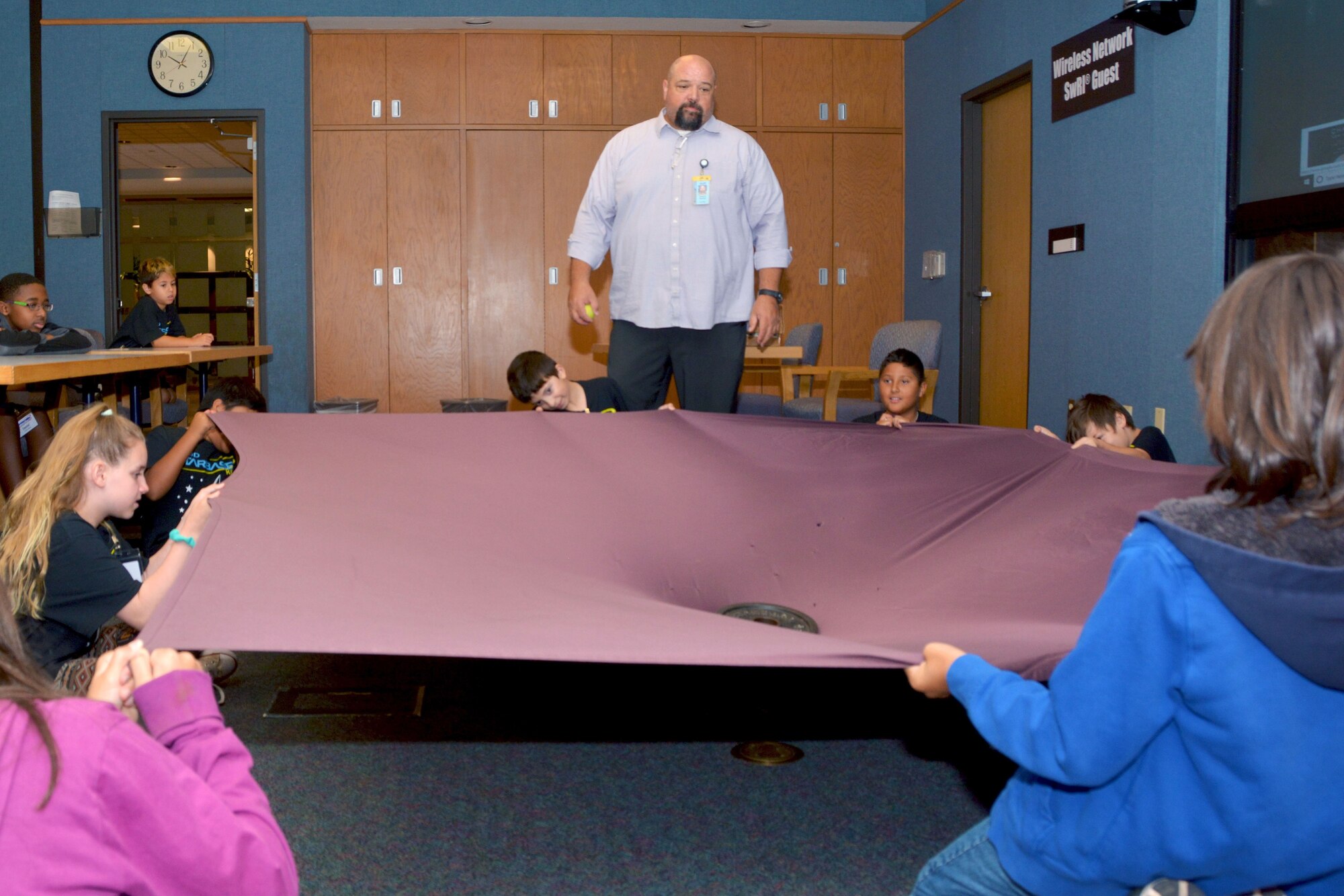 Gregory Fletcher, Southwest Research Institute Space, Science, and Engineering Division senior program manager, guides Starbase Kelly summer camp students through a gravity experiment at the Southwest Research Institute in San Antonio July 31. The students, who are attending a camp at Joint Base San Antonio-Lackland, received instruction and demonstrations from experts in the fields of science, technology, engineering and mathematics.