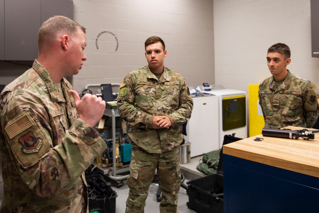 Ninth Air Force Command Chief Master Sgt. Benjamin W. Hedden, speaks to two aircrew flight equipment (AFE) Airmen from the 41st Rescue Squadron at Moody Air Force Base (AFB), Ga., July 30, 2019. During the visit, Hedden discussed the quality of life of Airmen living assigned to Moody AFB. (U.S. Air Force photo by Airman Azaria E. Foster)