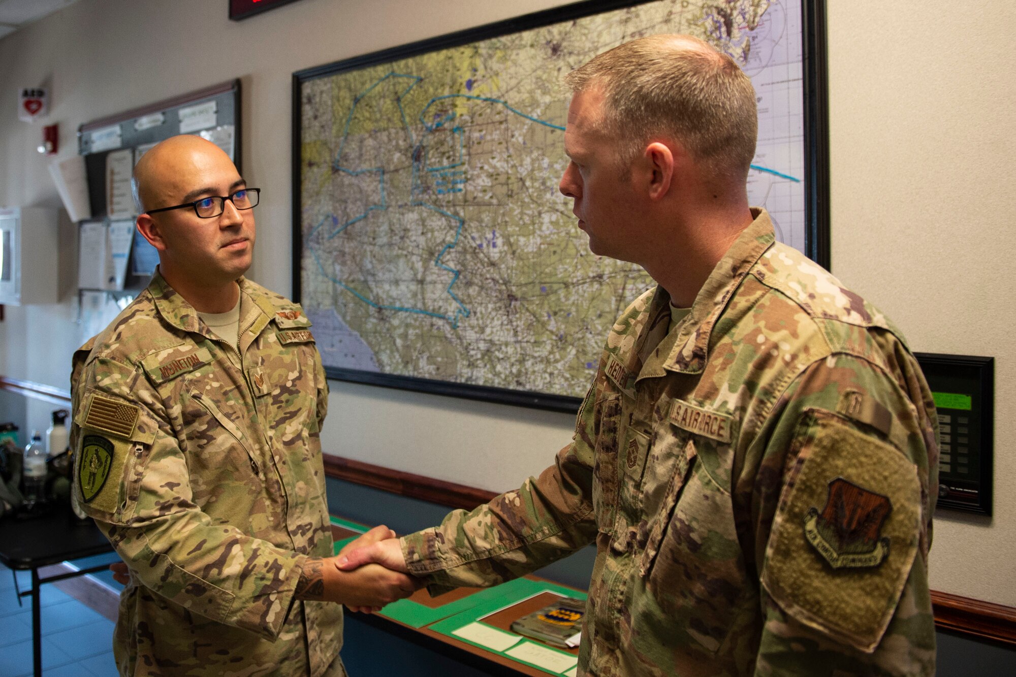 Ninth Air Force Command Chief Master Sgt. Benjamin W. Hedden, right, coins Tech. Sgt. Alvaro Muneton, 41st Rescue Squadron special mission aviator instructor, at Moody Air Force Base, Ga., July 30, 2019. Muneton was recognized for exceeding expectations while executing logistics plans for his unit’s predeployment training.(U.S. Air Force photo by Airman Azaria E. Foster)