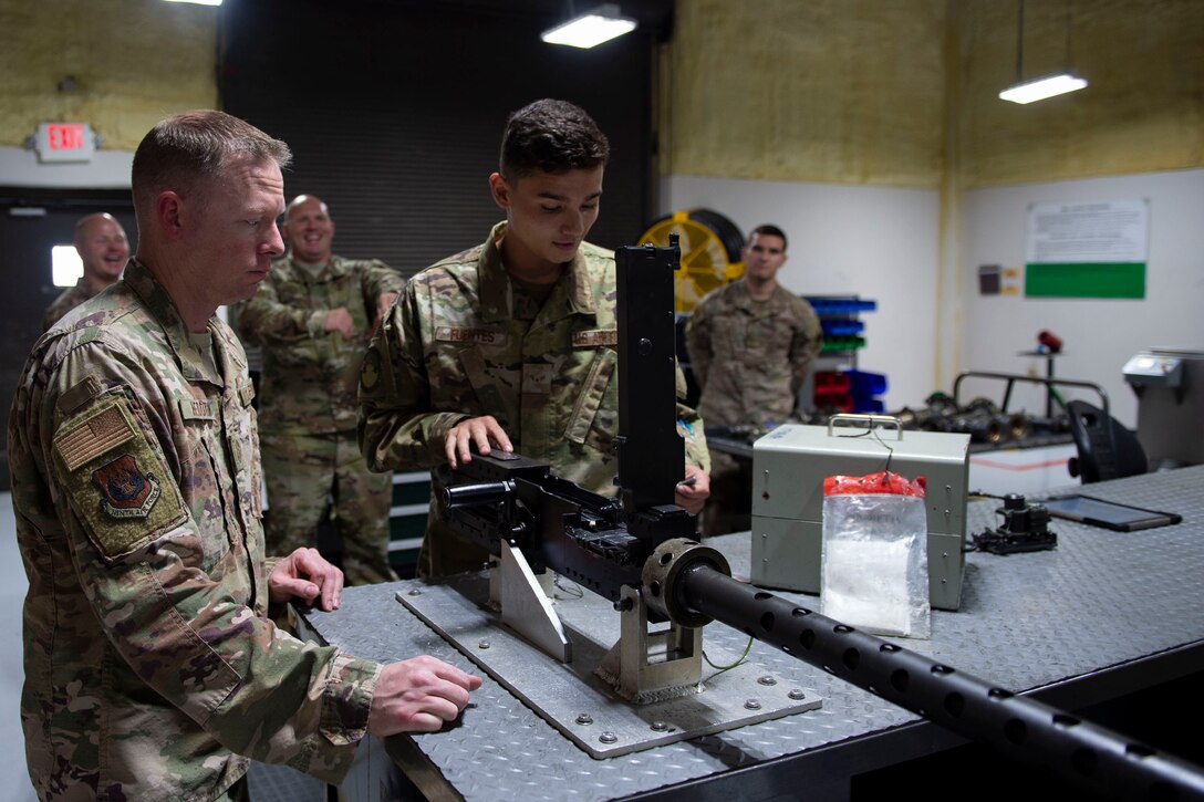 Airman 1st Class Nathaniel Fuentes, right, 723d Aircraft Maintenance Squadron (AMXS) weapons load crew member, explains how to fire a GAU-18/A to Ninth Air Force Command Chief Master Sgt. Benjamin W. Hedden, at Moody Air Force Base, Ga., July 30, 2019. The 723d AMXS is responsible for generating, mobilizing, deploying and employing forces to provide combat and peacetime search and rescue operations in support of U.S. national security interests. (U.S. Air Force photo by Airman Azaria E. Foster)