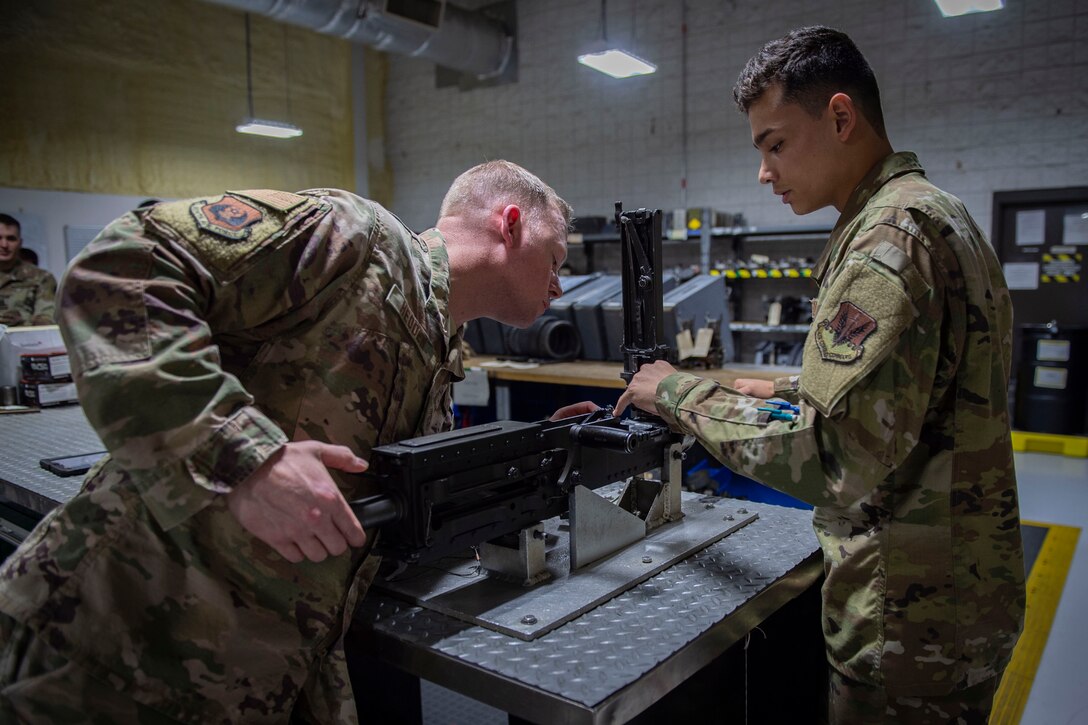 Airman 1st Class Nathaniel Fuentes, right, 723d Aircraft Maintenance Squadron (AMXS) weapons load crew member, explains how to fire a GAU-18/A to Ninth Air Force Command Chief Master Sgt. Benjamin W. Hedden, at Moody Air Force Base, Ga., July 30, 2019. The 723d AMXS is responsible for generating, mobilizing, deploying and employing forces to provide combat and peacetime search and rescue operations in support of U.S. national security interests. (U.S. Air Force photo by Airman Azaria E. Foster)