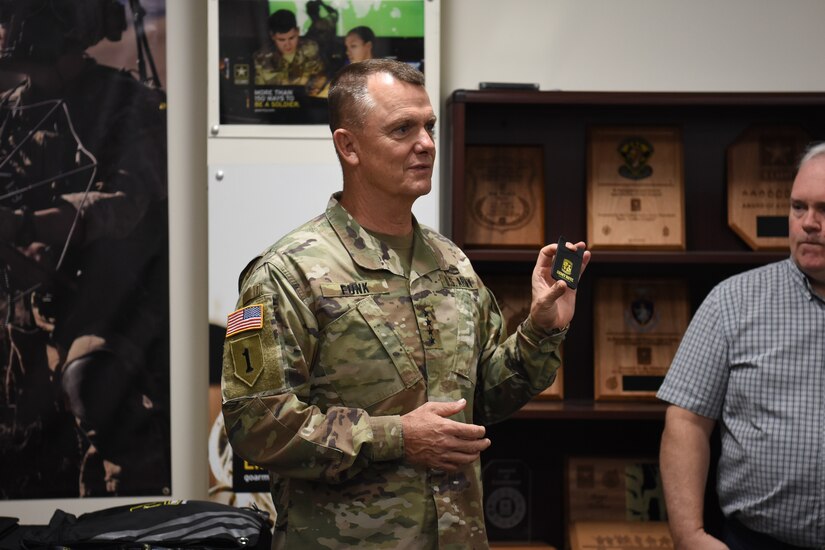 Gen. Paul Funk II, commanding general of U.S. Army Training and Doctrine Command, discusses the personal presentation items produced by the U.S. Army Marketing Engagement Brigade during a visit to the brigade headquarters at Fort Knox, Kentucky, Aug. 1. The MEB's mission is to support Army accessions. The unit does a variety of support operations, one being the production of presentation items for both U.S. Army Recruiting Command and U.S. Army Cadet Command. This was Funk's first visit to the brigade since taking command of TRADOC. (U.S. Army photo by Lara Poirrier)