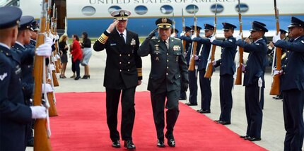 Military leaders salute while walking.