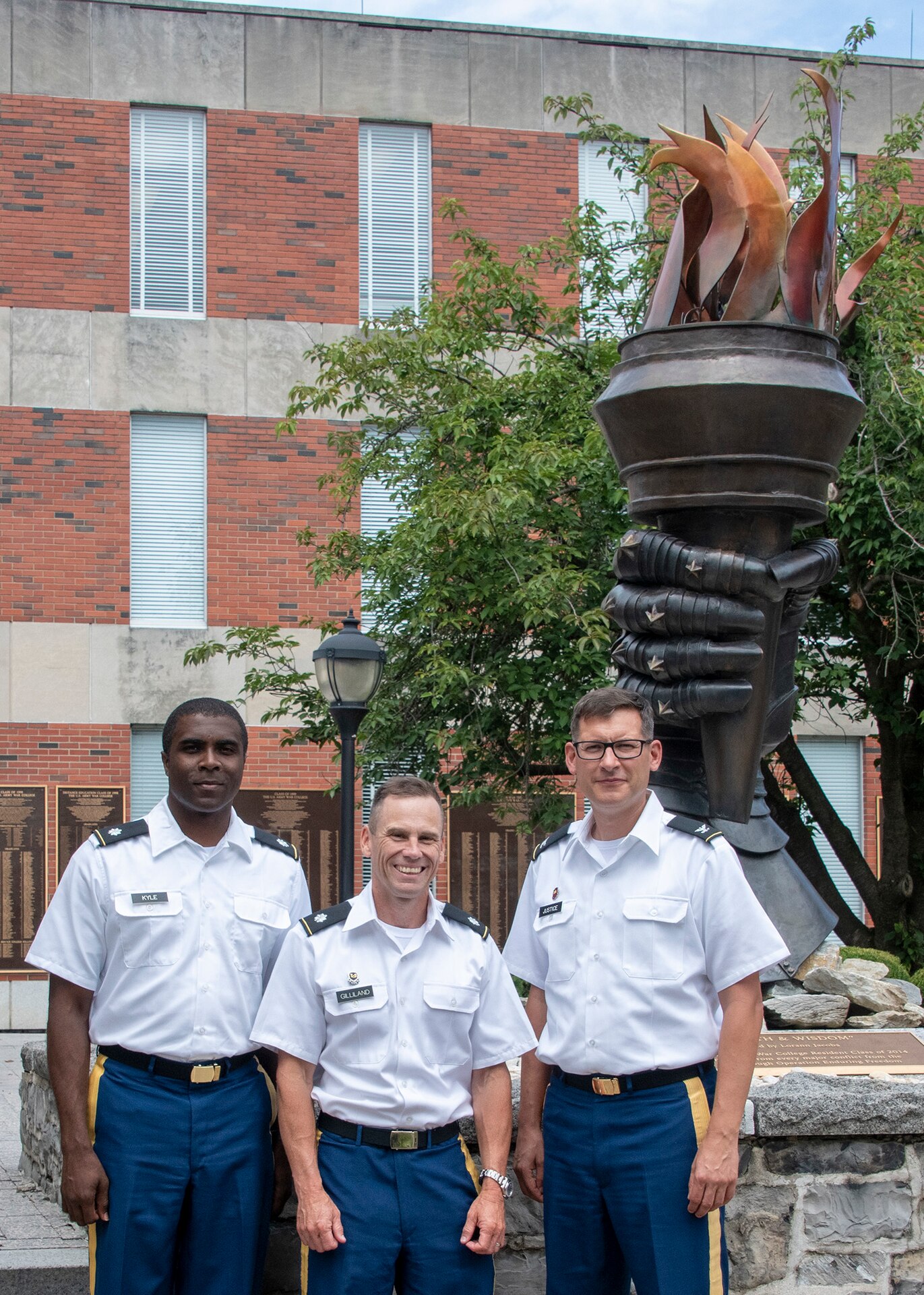 U.S. Army Reserve Lt. Col. Clifton Kyle, commander of the 457th Civil Affairs Battalion, 361st Civil Affairs Brigade, 7th Mission Support Command; Lt. Col. Kenneth Gilliland, command judge advocate for the 510th Regional Support Group, 7th MSC; and Col. Aaron Justice, commander of the 510th RSG, 7th MSC, pose for a photo outside the U.S. Army War College in Carlisle Barracks, Pennsylvania, on July 26, 2019. Five 7th MSC officers graduated the two-year program with a Master's degree in Strategic Studies.