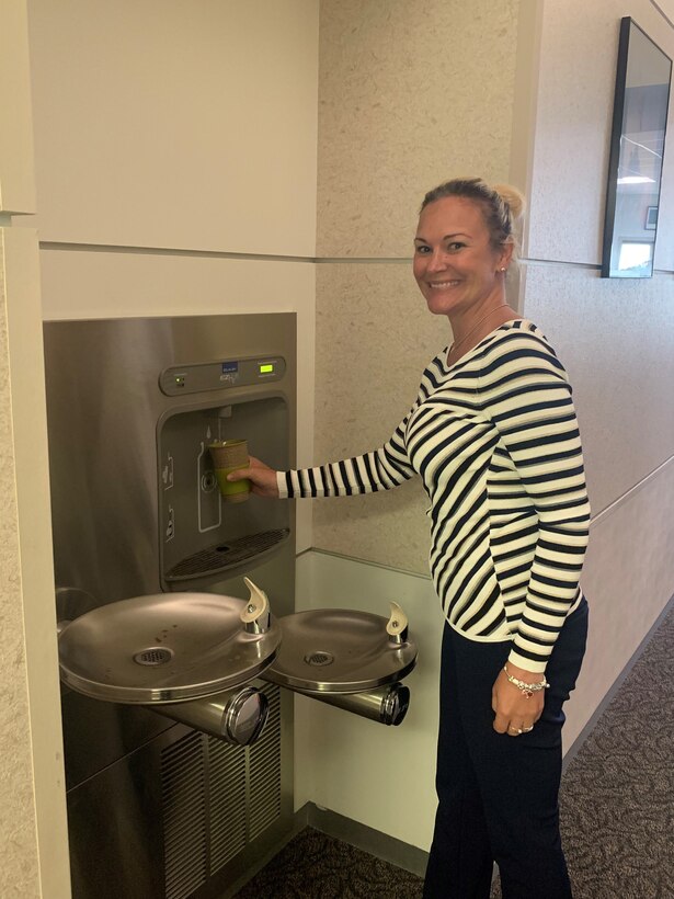 Woman fills water bottle at a station