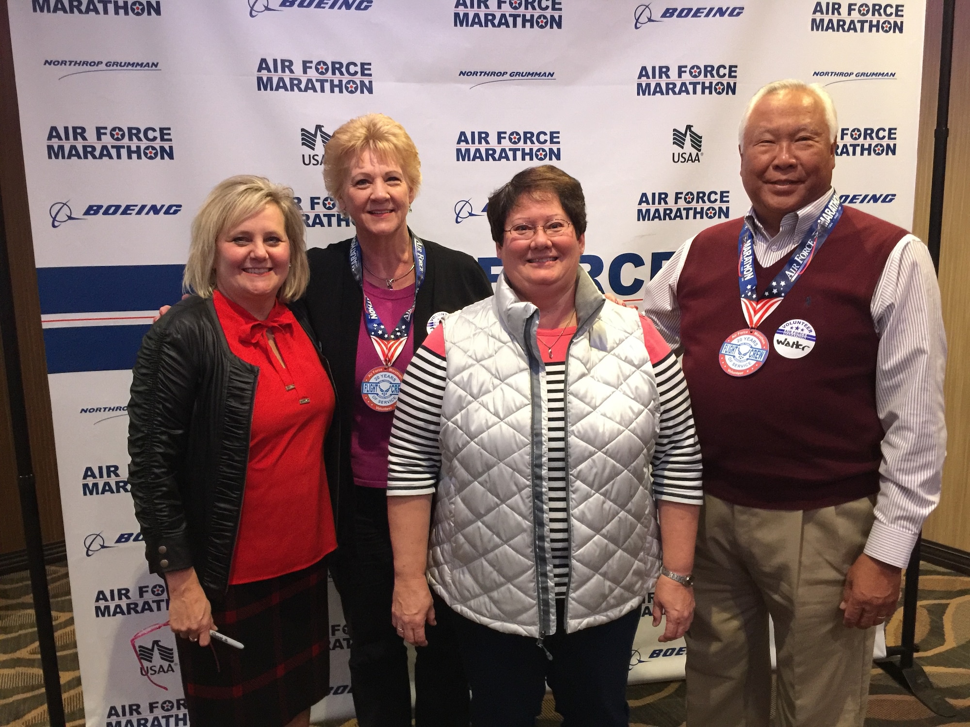 Left to right, Air Force Marathon volunteer coordinator Jeanette Monaghan, takes a photo with long time volunteers, Deniece Chin, Anita Kerns and Walter Chin. Volunteers like the Chins and Kern help make the annual event a success by assisting with one of the many functions of the marathon. Volunteer registration is currently open and will run through Aug. 31. All the open positions are listed on the marathon’s website, www.usafmarathon.com, and volunteers can register online. (Courtesy photo)