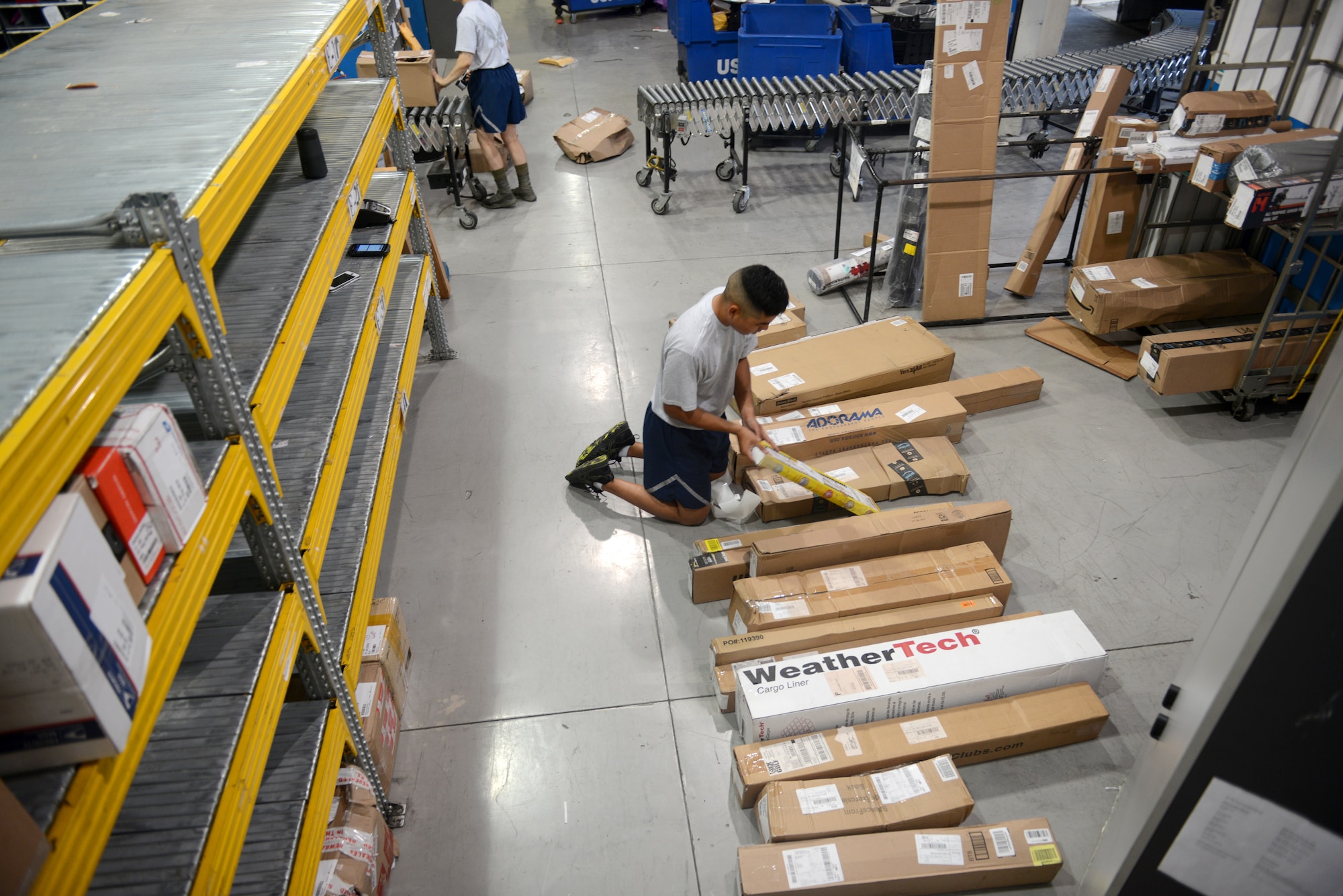 Airman 1st Class Valeriano DeLeon III, a military postal clerk from the 31st Force Support Squadron, labels packages to be placed on the shelf from an early morning shipment, Aug. 2, 2019, at Aviano Air Base, Italy. DeLeon worked the first morning shift where they unloaded a semi-truck of mail. (U.S. Air Force photo by Airman 1st Class Ericka A. Woolever)