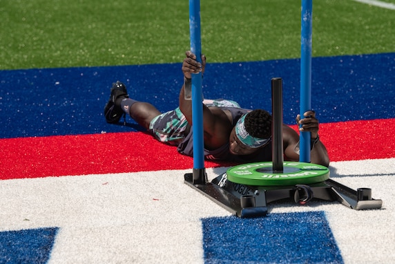 Capt. Chandler Smith, a member of the U.S. Warrior Fitness Team, competes in the men's individual competition at the 2019 CrossFit Games in Madison, Wis., Aug. 2 2019. During the fourth round, Smith had to complete a 172-foot sled push, 18 bar muscle-ups, and another 172-foot sled push to the finish line in under six minutes. (Photo Credit: Devon L. Suits)