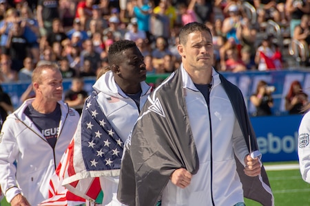 Lt. Col. Anthony Kurz and Capt. Chandler Smith, representing the U.S. Army Warrior Fitness Team, march onto the field during the 2019 CrossFit Games opening ceremony in Madison, Wis., Aug. 1, 2019. Kurz proudly displayed his U.S. Army Special Forces flag as a nod to the Special Forces community. (Photo Credit: Sgt. 1st Class Robert Dodge)