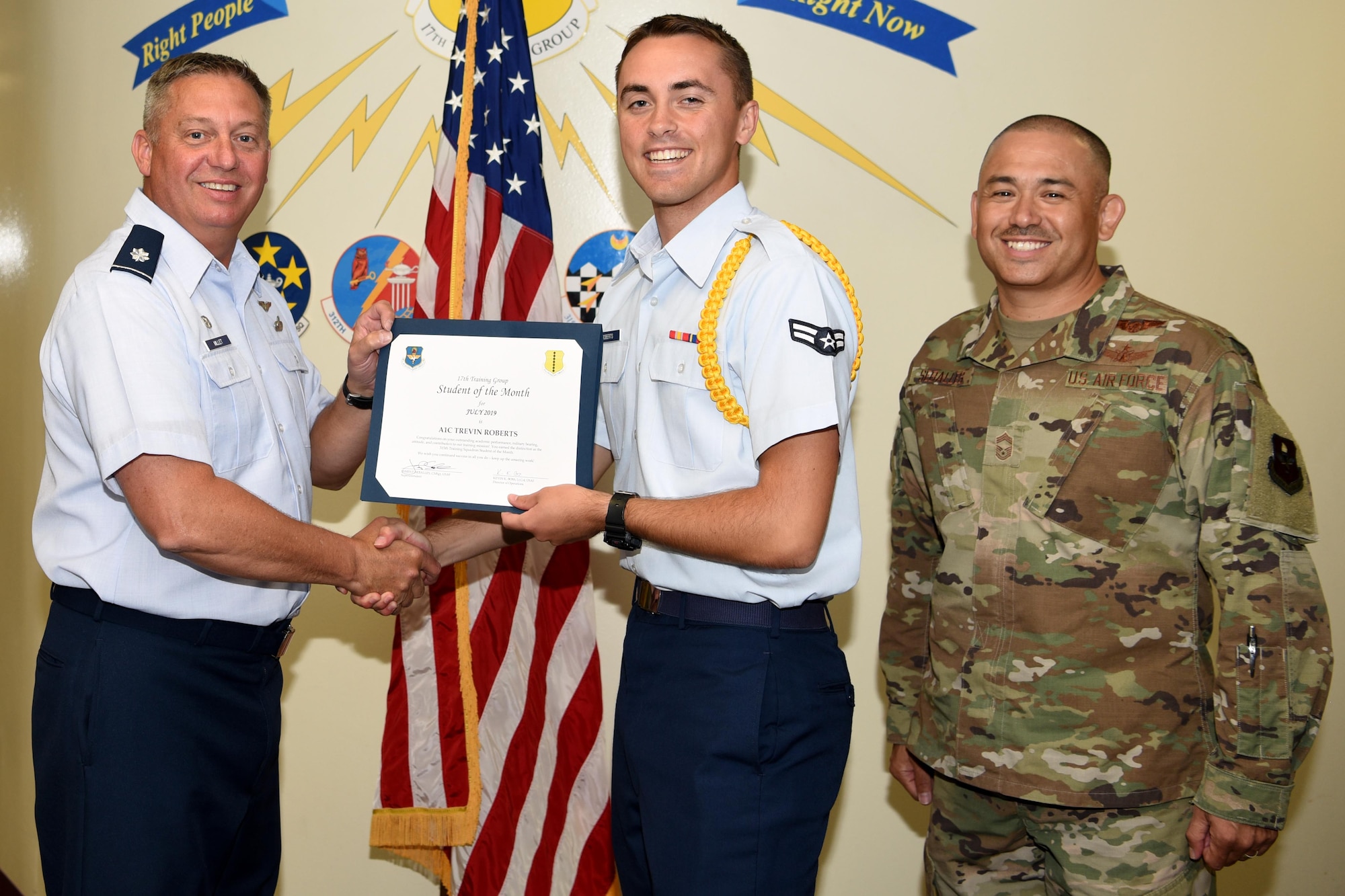 U.S. Air Force Lt. Col. Herbert Millet III, 313th Training Squadron commander, presents the 315th Training Squadron Student of the Month award to Airman 1st Class Trevin Roberts, 315th TRS student, at the Brandenburg Hall on Goodfellow Air Force Base, Texas, August 2, 2019. The 315th TRS’s vision is to develop combat-ready intelligence, surveillance and reconnaissance professionals and promote an innovative squadron culture and identity unmatched across the U.S. Air Force. (U.S. Air Force photo by Airman 1st Class Abbey Rieves/Released)