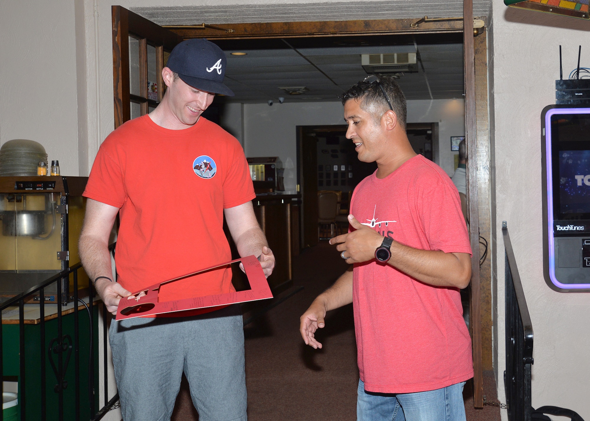 Capt. Andy Stalford, left, 343rd Reconnaissance Squadron, receives a mock gift from Lt. Col. Nelson Tirdado, right, 343rd commander, at Fraternal Order of Eagles in Bellevue, Nebraska, July 12, 2019, at the squadron’s Roll Call. Traditionally the roll was to account for personnel after a deployment. It is used today by the 343rd as a morale booster and to highlight past mistakes so current and future Airmen can learn from them. The Fraternal Order of Eagles offered a room to the 343rd for heritage events after their building was destroyed by flood waters on Offutt earlier this year.