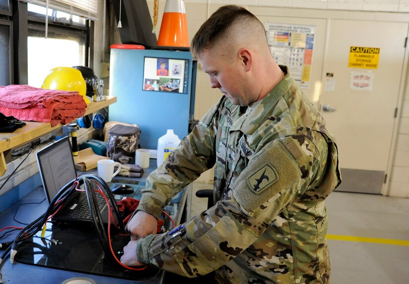 Sgt. Scott Witthuhn explains the new power switch he invented for a family of skid steer loaders with recurrent dead battery problems.