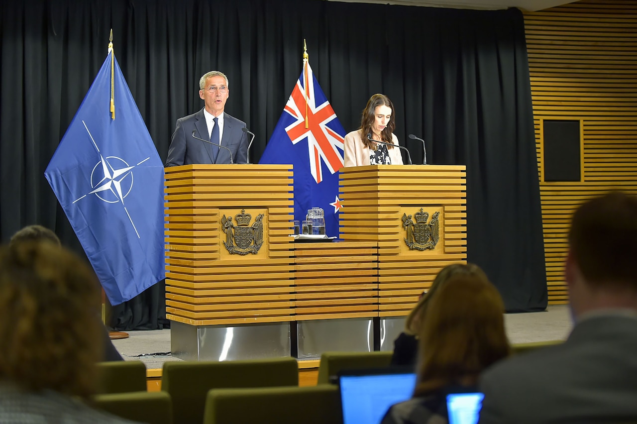 Two people stand behind lecterns.