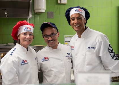 Senior Airman Juan Ramirez Ceballos, center, with the 628th Force Support Squadron, poses for a photo with Gen. Maryanne Miller, left, commander of Air Mobility Command, and Chief Master Sgt. Terrence Greene, AMC command chief master sergeant, at the Gaylor Dining Facility at Joint Base Charleston, South Carolina, July 30, 2019. Miller and Greene visited JB Charleston July 29 to August 1 to get a first-hand look at mission capabilities, new innovative programs and how JB Charleston is taking care of its service members to build a stronger mobility force.  The dining facility re-opened February 2019 after a two-year renovation. The renovations help dining facility personnel adjust to changing dietary needs and preferences, and improves efficiency and reduces costs while maintaining mission feeding capabilities.