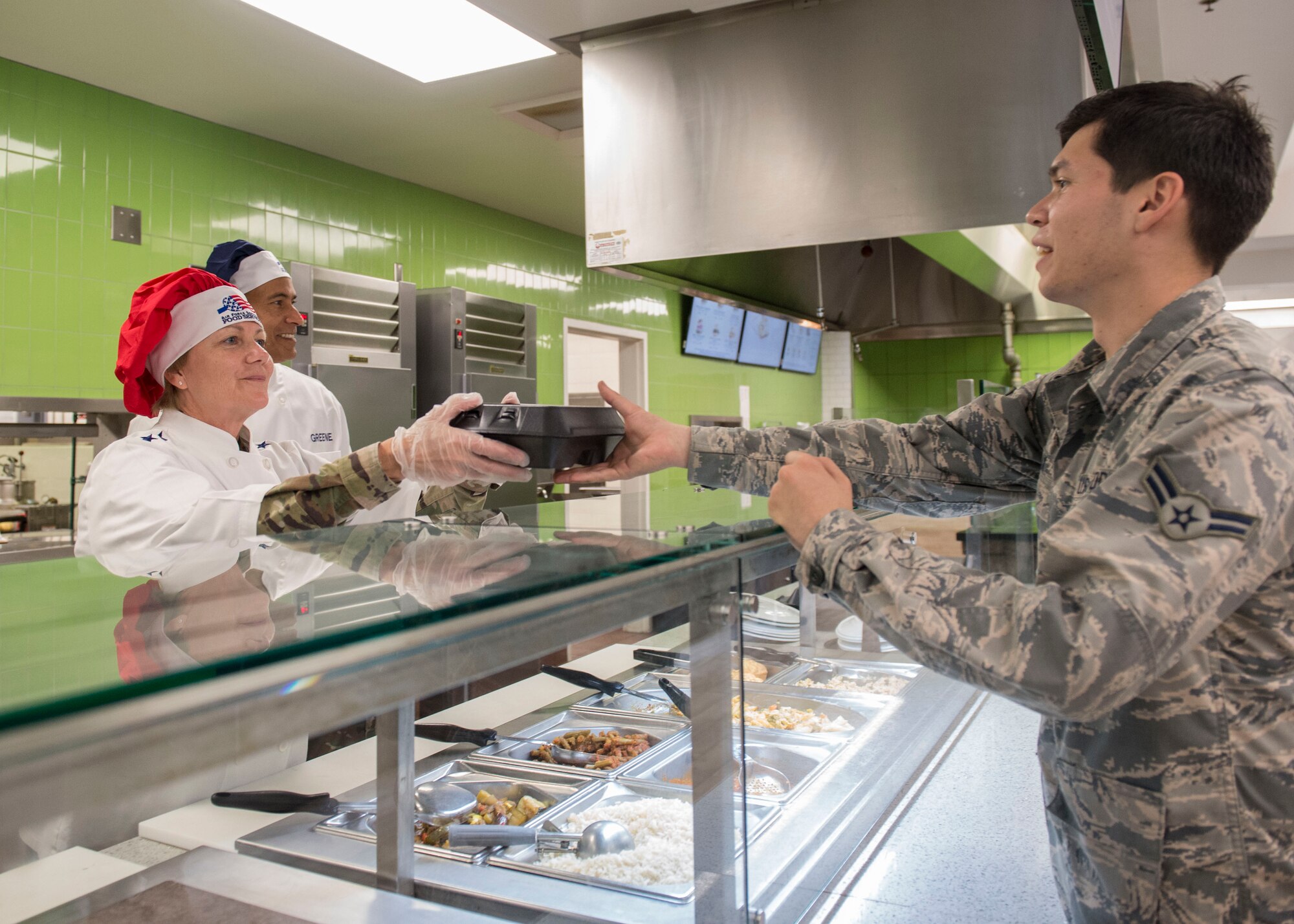Gen. Maryanne Miller, left, commander of Air Mobility Command, and Chief Master Sgt. Terrence Greene, AMC command chief master sergeant, serve an Airman food at the Gaylor Dining Facility during a visit to Joint Base Charleston, South Carolina, July 30, 2019. Miller and Greene visited JB Charleston July 29 to August 1 to get a first-hand look at mission capabilities, new innovative programs and how JB Charleston is taking care of its service members to build a stronger mobility force.  The dining facility re-opened February 2019 after a two-year renovation. The renovations help dining facility personnel adjust to changing dietary needs and preferences, and improves efficiency and reduces costs while maintaining mission feeding capabilities.