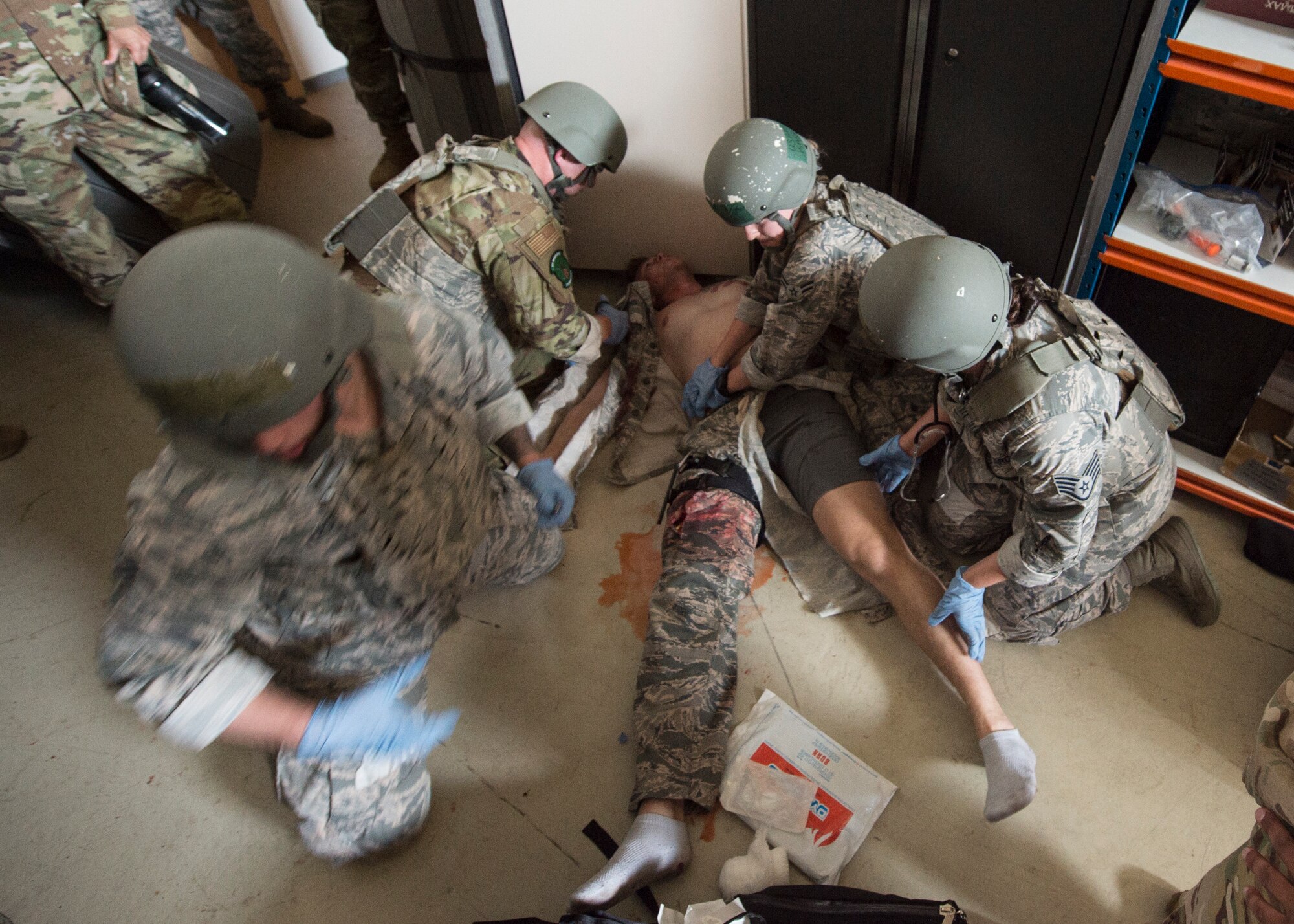 Medics respond to a simulated combat scenario of a victim with bullet wounds during the U.S. Air Forces in Europe EMT Rodeo at Ramstein Air Base, Germany, July 23, 2019. Training victims responded like real casualties by screaming, flailing, being disoriented, and noncompliant. (U.S. Air Force photo by Staff Sgt. Kirby Turbak)