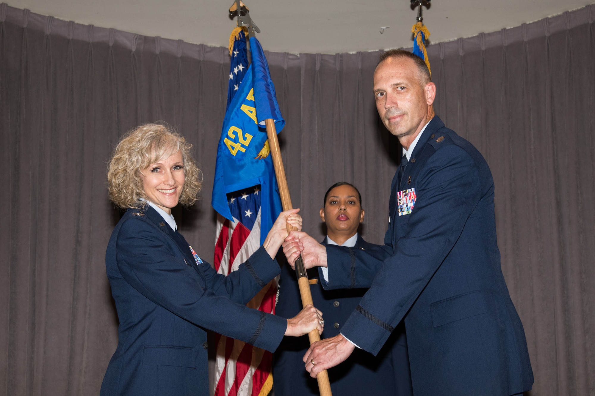 Colonel Jeanette Frantal, 42nd Medical Group commander, hands the unit flag for the 42nd Operational Medical Readiness Squadron to Lt. Col. Scott Corey, OMRS commander, during a medical group squadrons’ re-designation ceremony Aug. 5, 2019, Maxwell Air Force Base, Alabama. The 42nd Aerospace Medicine Squadron was re-designated the 42nd OMRS, which will focus on active duty care, as part of Defense Department reforms to the Military Health System. (U.S. Air Force photo by William Birchfield)