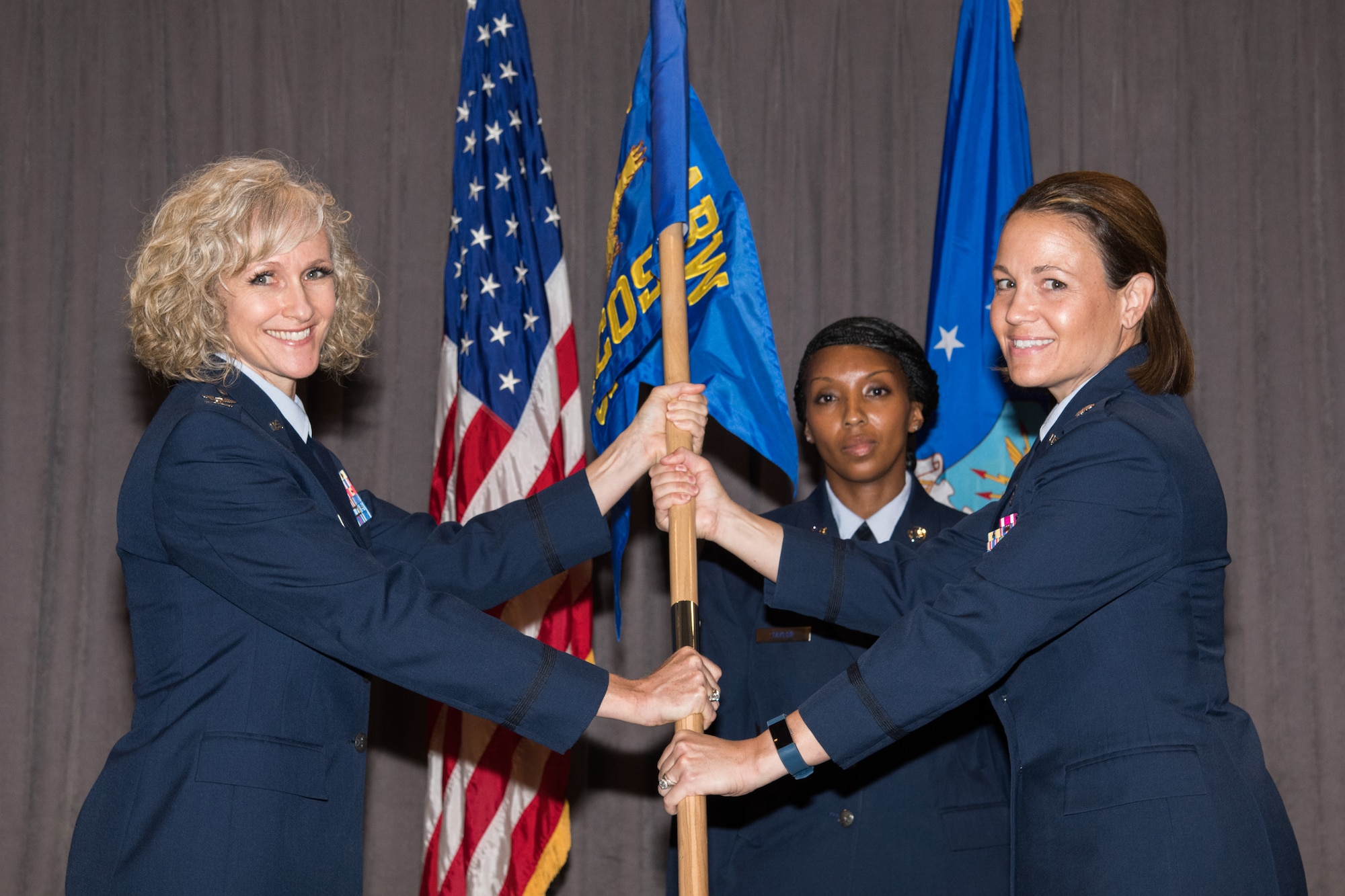 Colonel Jeanette Frantal, 42nd Medical Group commander, hands the unit flag for the 42nd Health Care Operations Squadron to Lt. Col. Melissa Runge, HCOS commander, during a medical group squadrons’ re-designation ceremony Aug. 5, 2019, Maxwell Air Force Base, Alabama. The 42nd Medical Operations Squadron was re-designated the 42nd HCOS, which will focus on military family member, non-active duty and retiree health care, as part of Defense Department reforms to the Military Health System. (U.S. Air Force photo by William Birchfield)