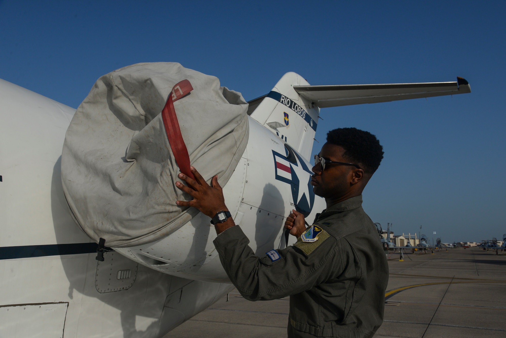 47th Flying Training Wing Class 19-17 graduate and Order of Daedalians AETC Commander’s Trophy recipient, 1st Lt. Tyler Weaver, covers one of the engines of a T-1A Jayhawk at Laughlin Air Force Base, Texas, July 31, 2019. The AETC Commander’s Trophy is one of the highest accolades Air Education and Training Command has to offer.