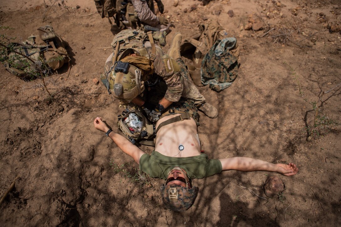 A U.S. Marine with Special Purpose Marine Air-Ground Task Force-Crisis Response-Africa 19.2, Marine Forces Europe and Africa, is treated for simulated injuries by a U.S. Air Force pararescue jumper during quick-reaction force training in Thiés, Senegal Aug. 5, 2019