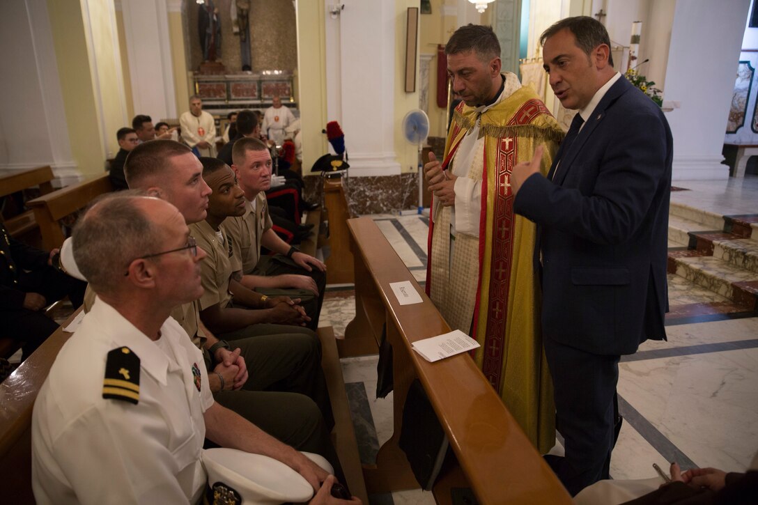 U.S. Marines and a Sailor with Special Purpose Marine Air-Ground Task Force-Crisis Response-Africa 19.2, Marine Forces Europe and Africa, speak with the bishop of the local church after a parade in Nissoria, Sicily, Italy, Aug. 4, 2019