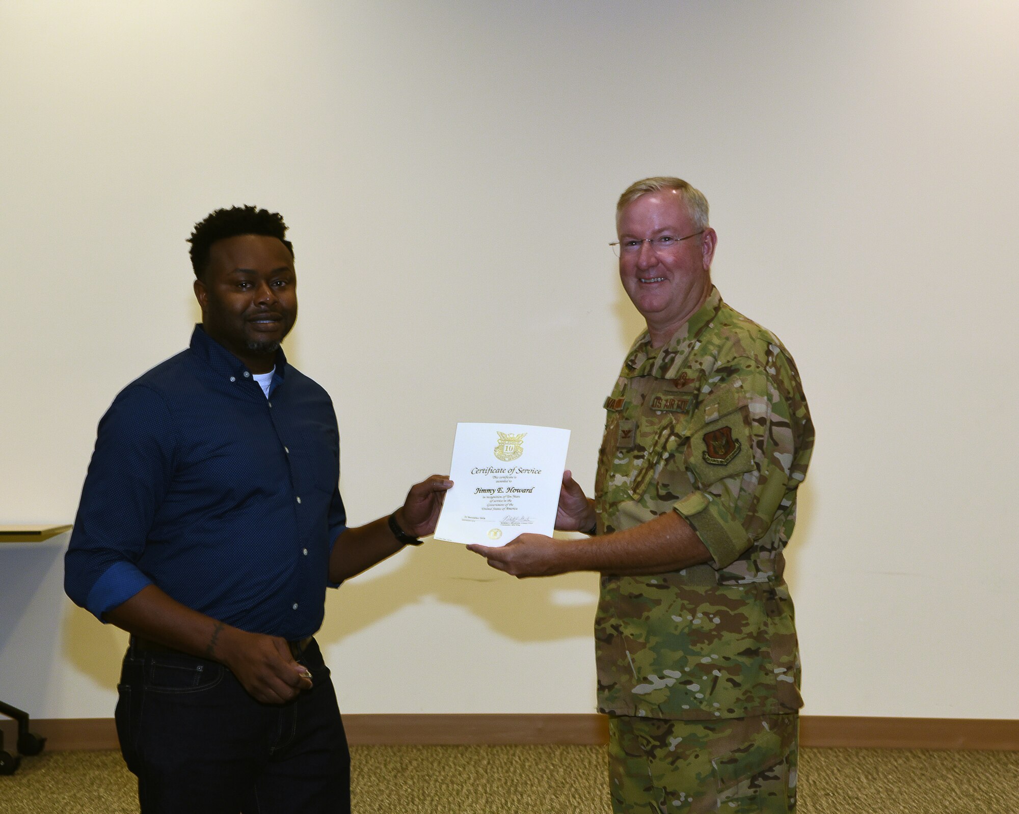 Col. Jeffery Van Dootingh, 403rd Wing commander, presented Jimmy Howard, a civilian in the 403rd Finance Office, with his 10-year service certificate, Aug. 6, 2019 at the Roberts Consolidated Maintenance Facility Auditorium, Keesler Air Force Base, Mississippi.  Van Dootingh held his first civilian commanders call, where he presented service certificates and welcomed new members to the 403rd Wing. (U.S. Air Force photo by Jessica L. Kendziorek)