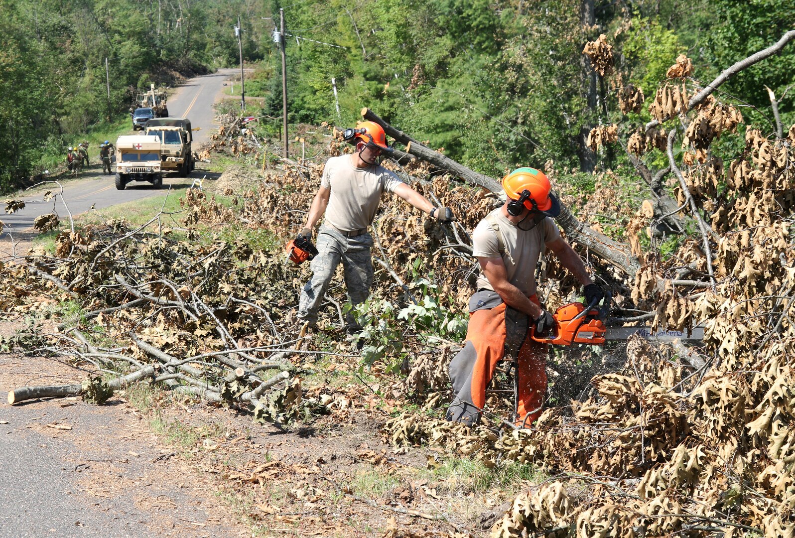 Staff Sgt. Cody Koeller, left, a part of the 115th Fighter Wing’s security forces and Tech. Sgt. Andrew Melton, a munitions technician with the 115th, right, cut through dense debris along the roadways near Loon Lake in Barron County, Wis., Aug. 3, 2019, as part of the continued recovery efforts in Polk and Barron Counties. Approximately 100 Soldiers and Airmen from the Wisconsin Army and Air National Guard remain on duty to assist civil authorities with damage assessment and debris clearance following the severe weather that struck Northern Wisconsin July 19-20.