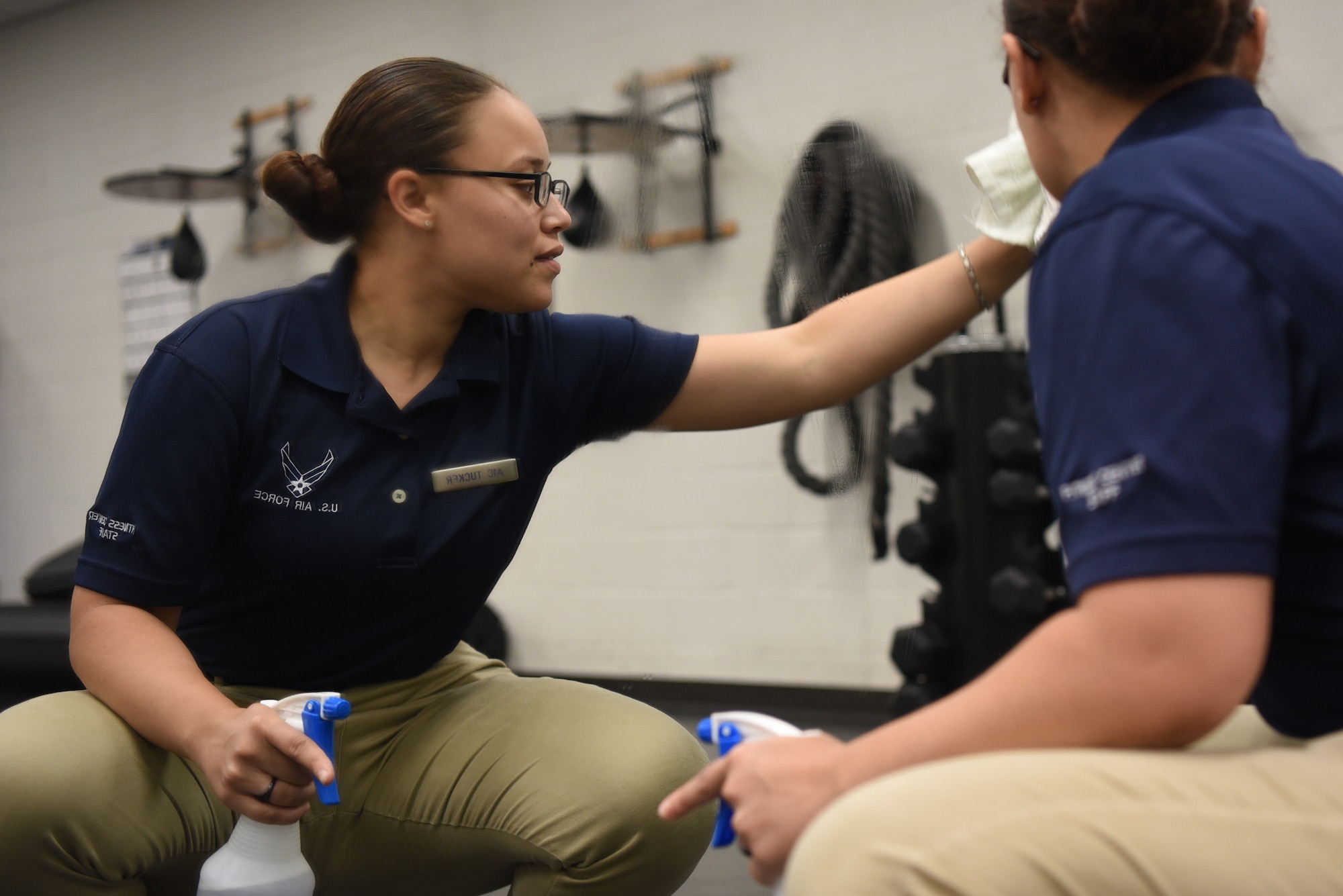 Airman 1st Class Sasha Tucker, 22nd Force Support Squadron fitness journeyman, cleans a mirror Aug. 6, 2019, at McConnell Air Force Base, Kan. The center is cleaned daily by the team of 15 Airmen who, re-rack weights, ensure all equipment is sanitized and do laundry hourly. These FSS Airmen keep the gym clean and functional for over 550 visitors daily. (U.S. Air Force photo by Airman 1st Class Alexi Myrick)