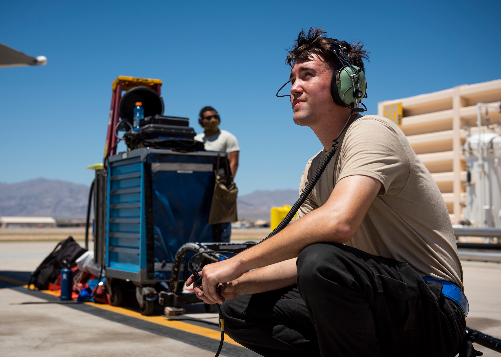 Airman sits on the floor of the flight line.